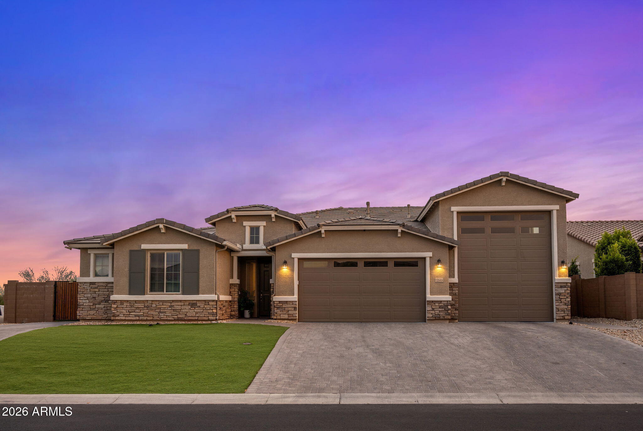 Located in Glendale minutes from State Farm Stadium and Westgate Entertainment District, this single-level home sits on a .29-acre corner lot in a single-story gated community. A stone-accented exterior leads to a two-car garage and a 43-foot RV garage with RV dump and car lift. Inside offers an open layout with tile flooring, fireplace, and sliding glass doors. The kitchen features granite counters, large island, ample cabinetry, and walk-in pantry. Four bedrooms and four baths including a spacious primary suite with 2 walk-in closets. A bonus room en-suite with private access to backyard adds flexibility. The backyard includes a pool, spa, water feature, travertine, turf, covered patio, outdoor fireplace, and built-in kitchen.