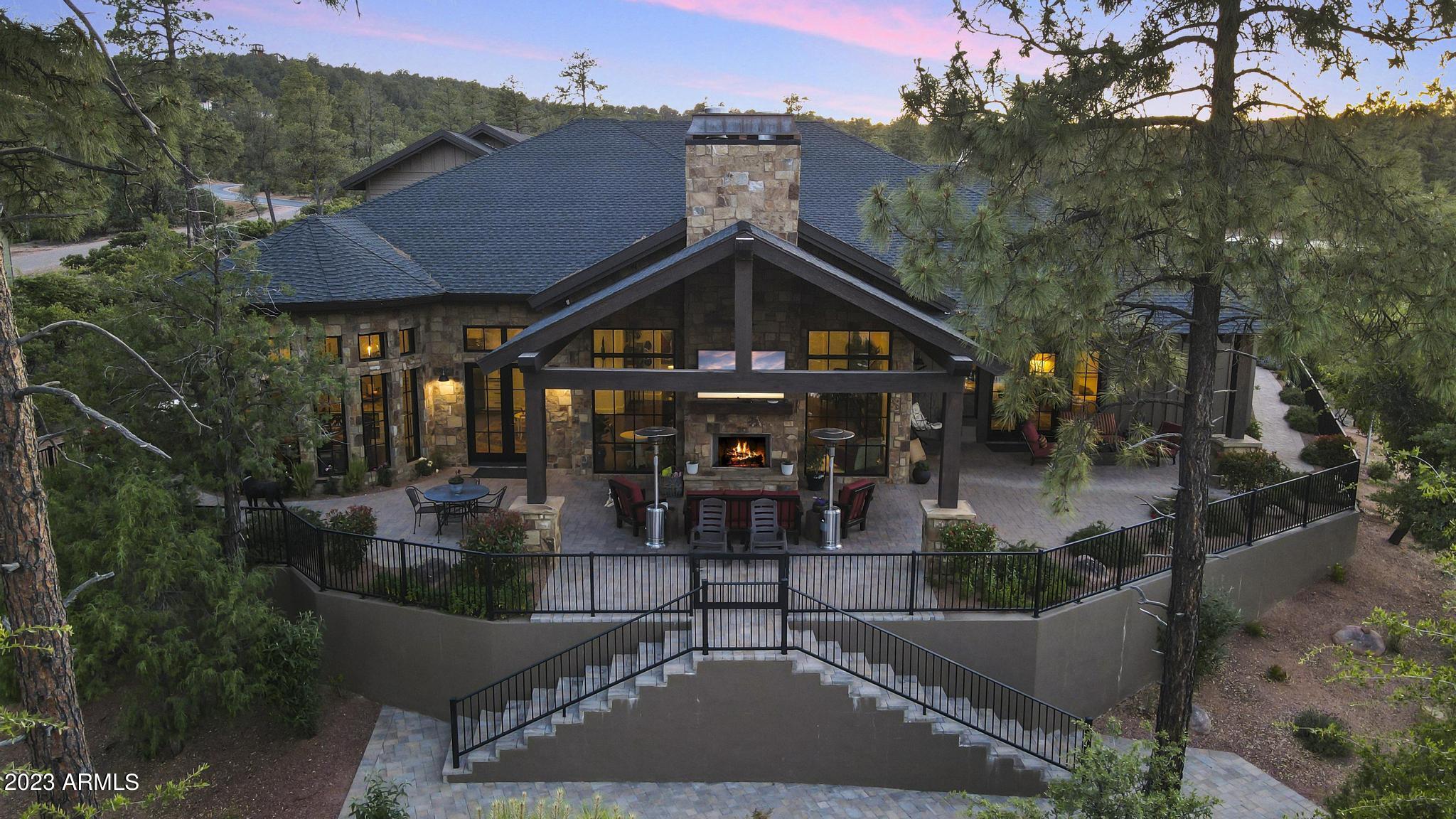 Mountain elegance with the WOW factor! Built by a builder for himself, so much to admire and appreciate. This beauty is nestled on just under 1 acre of landscaped art and has water on 2 sides with mountain views. Driveway and patios are oversized and done in Aker 4 piece desert blend pavers. Siding is a concrete board with a 50 year GAF asphalt composition shingle roof with metal accents. Custom large front door is highlighted by elegant chandeliers both inside and out. Flooring is engineered hard wood throughout and Italian marble in all baths. 14' ceilings boast faux beams and all fireplaces are gas and covered in Telluride blend stone to match the exterior of home. Kitchen is an entertainers delight and a chefs dream. All appliances are SS Wolfe Subzero and cabinets are solid wood soft close with upgraded handles and lots of storage. Large kitchen island can seat many guests and Butler's Pantry can host wonderful evening gatherings. Home has 4 bedrooms with a possible 6, 2 offices, 3 bedrooms are located above garage, 2 family rooms, formal dining room, separate sitting room with FP, Childs play room, and a heated and cooled work out room with mirrors. Energy efficiency is a trademark of this builder with spray foam insulation and all electric minus the FP's and gas cooktop. Garage is a dream and holds 5 cars and has epoxy flooring. Outdoor living can easily be done from the covered patios and built in BBQ and there is even a firepit to enjoy the cool starry nights. So much to mention with all this home holds. Please visit the documents tab for the Features Sheet and further description. You won't want to miss this one.