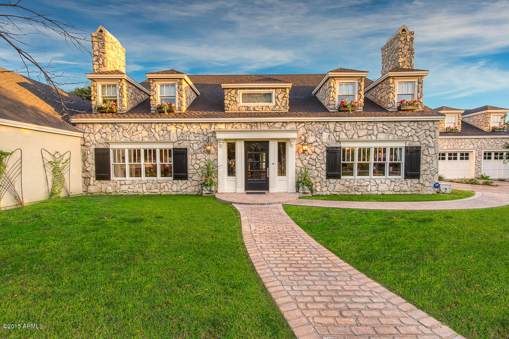 *Priced below Appraisal!*The dappled sunlit brick walkway winds you to the front door of this exquisite Old English style country estate. Every detail, from the thick wood crown molding and wainscoting to the custom doors and windows to the built-in bench under the stairway, is done to designer perfection with whimsical touches that make this home truly unique. The foyer leads to a tranquil formal living room with gas fireplace. Across the foyer sits the formal dining with gas fireplace and hidden wine service fridge. The comfortable and very large cook’s kitchen invites you to have a glass of wine and help prepare a fabulous meal in the 6 burner + grill Thermador oven encased in a unique stone hearth. If the huge custom wood & black granite island is full, find a seat in the spacious eat-in which is surrounded by windows looking to the backyard and pool. The master suite leaves nothing to be desired with a separate study with french doors, gas fireplace, private master courtyard with fountain, his/hers bathrooms suited to each with their own large walk-in closets. Upstairs there are 3 more generous and unique bedrooms + loft space for the kids to hang out or do homework. Lovely and endearing features like potted terraces, private kid nooks with lighting that are wired for cable and child-height switches create a special space for children or teens. Above the pavered driveway and 3 car garage is an 850 SF 1 BR with new AC, living, kitchen and full bath. The backyard offers plenty of grassy space, mature trees including grapefruit, lemon & kumquat, custom built pool + spa, covered patio with 2-sided fireplace and pool house with bar, hang out space and a low maintenance bath. The latest security system and dedicated infrared camera + 4 movable cameras all controlled from your iPhone or tablet, in-wall speakers, landscape lighting and Camelback views make this estate one-of-a-kind.