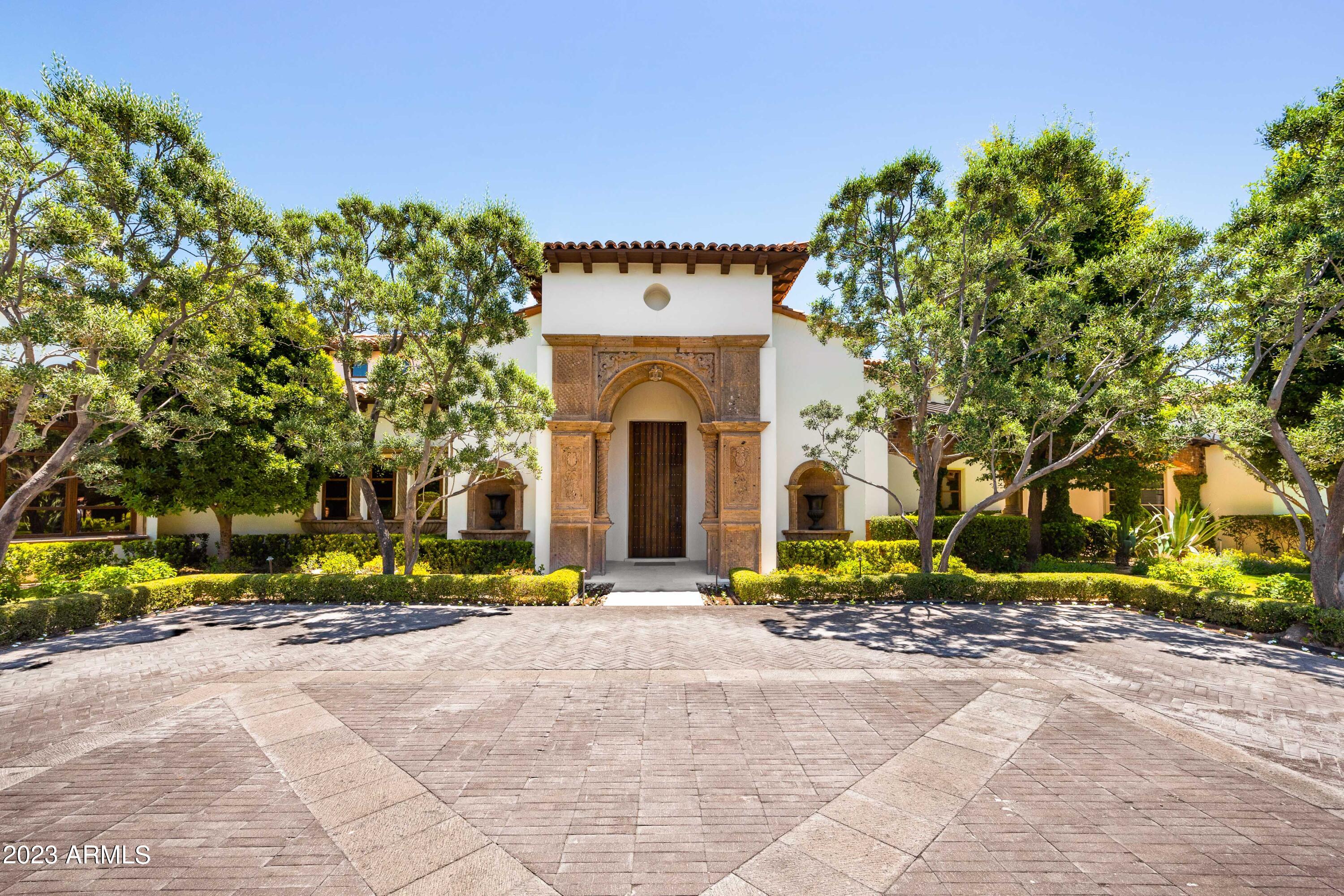 Welcome to Paradise Valley's best kept secret.  Tucked away and hidden behind private gate, you'll find this one of a kind Spanish Colonial estate that will leave you speechless.  Meticulously crafted with timeless elegance and state of the art technology.  Lush, manicured landscaping that rivals any Arizona resort, this move-in ready compound features 13,000 sqft, 4 bedrooms in the main house plus 2 office, and downstairs game room plus a 21 seat movie theatre.  Poggenpohl modern kitchen, formal dining/butler's pantry and wine room.  Two detached guest houses, both with full kitchens, perfect for hosting out of town guest and separate gym/studio space.  Full tennis court, basketball hoop, rooftop viewing deck, sparkling pool/jacuzzi, breathtaking gardens and 7 car garage.