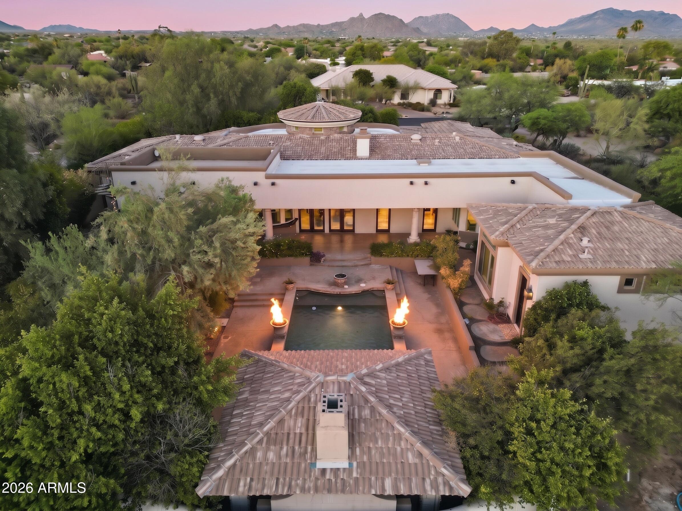 Spectacular custom one of a kind, incredibly located no HOA Scottsdale estate with full casita where timeless craftsmanship, artisan details, and breathtaking scenery come together. Arrive to a circular driveway surrounded by mature Sonoran desert landscaping leading to a lush courtyard with a tranquil fountain and ample seating space. Enter into dramatic formal living room showcasing 22-foot coffered ceilings, hand carved fireplace, private office, wet bar with grand architectural radius windows that frame incredible mountain views while filling the home with natural light. Main home features 3 bedrooms with full ensuite bathrooms- split floor plan including large bonus room on primary wing with outdoor access, primary bedroom has dual fireplace, serene seating area with incredible views. The private 485-square-foot guest house is connected by a breezeway and features its own iron door entrance from side yard. Casita offers large living space, kitchenette, full bath, separate HVAC system, water heater, creating endless flexibility for guests, multigenerational living, or a private retreat.

Thoughtfully selected finishes throughout both homes include Bavarian Cherry hardwood floors, Turkish travertine, solid alder doors, custom alder cabinetry, solid cedar exterior doors, and custom glasswork by award-winning Southwest artist Bob Berg. Oversized 3 car garage with built in cabinetry and plenty of room to spare, plus ample paved parking on side yard. 

Designed to embrace Arizona's indoor-outdoor lifestyle, the backyard features a resort-style pool with water and fire features, separate spa, outdoor kitchen, and expansive sunken pergola with a wood-burning fireplace. A custom spiral staircase leads to a reinforced view deck capturing spectacular 360-degree views, unforgettable sunsets, and the surrounding mountain landscape.

Tucked into the scenic beauty of North Scottsdale, this estate offers exceptional privacy, no neighbors behind, premium custom details throughout, and a level of character, craftsmanship, and charm rarely found. Conveniently located just minutes from world-class golf at Troon, expansive hiking trails, Boulders and Four Seasons Resort & Spa, and easy loop 101 access.