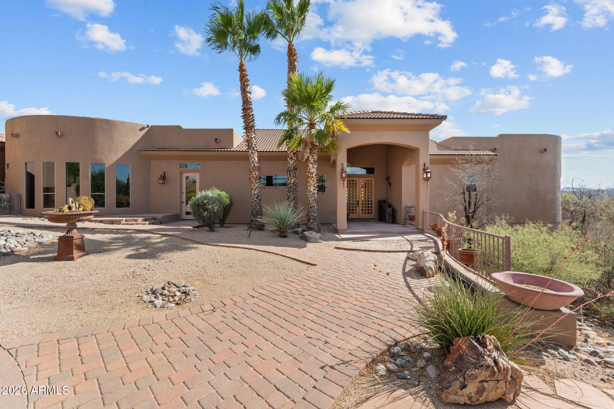 Set on 5 sprawling acres with breathtaking mountain views, this exceptional ranch offers the perfect combination of luxury living, aviation access, and equestrian living. The property features a 2,000 sq. ft. airplane hangar with direct runway access, This property was designed for entertaining and everyday comfort, the home showcases a chef's kitchen with premium Viking appliances, custom wood cabinetry, handcrafted countertops, and beautiful stone accents throughout. The flexible floor plan is perfectly suited for multigenerational living, featuring a custom dividing door that allows the home to function as two separate living quarters. Each side offers its own private entrance, kitchen, dining area, living room, fireplace, and private living space. One wing of the home is designed for entertaining, complete with a spacious game room featuring a pool table, shuffleboard, wet bar, and media room. The oversized laundry room includes double washers and dryers for added convenience. Outdoor living is equally impressive with a resort-style pool and spa, built-in BBQ, synthetic grass, and a spectacular wraparound deck spanning the length of the home--perfect for enjoying Arizona sunsets, entertaining guests, or relaxing while taking in the rolling hill views.Equestrian amenities include six horse pens with ample room to expand by adding additional horse pens, a large shop, barn, arena, or other improvements to create your ideal ranch setup. Located on a paved road, the property also provides abundant parking for trailers, RVs, aircraft, and guests.This is a rare opportunity to own a one-of-a-kind Arizona estate where aviation, luxury, and country living come together in one remarkable property.