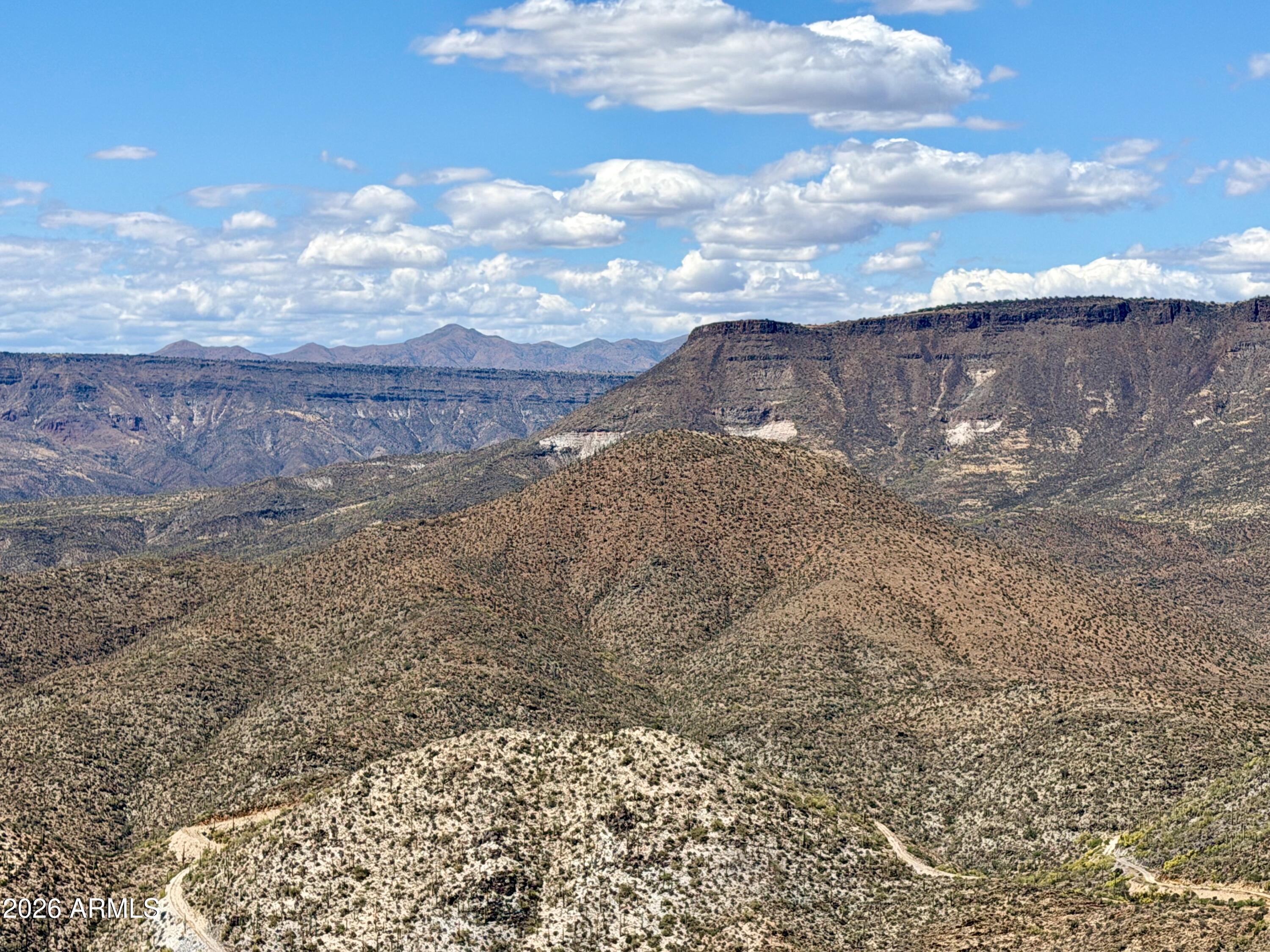 This unique 65+ acre property includes five irregularly sized parcels offering exceptional potential for future development. While direct road access is not currently established, access can be created. A completed survey provides added clarity  for planning. Bordering the 3.3-million-acre Tonto National Forest, the land features breathtaking panoramic views,  rolling hills, and a natural landscape rich with wildlife. Springs are present in the surrounding area demonstrating a potential water source.
Located just over the hill from the prestigious Desert Mountain development and north of Continental Mountain, this property combines seclusion with proximity to high-end growth areas--making it an outstanding speculative investment opportunity.