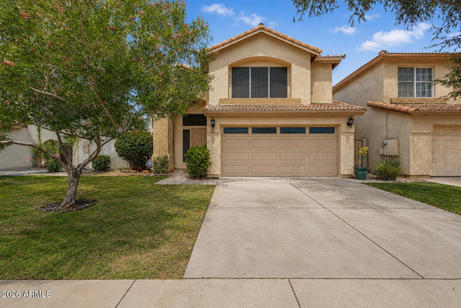 Beautifully updated home in the quiet and friendly Stapley Greens community in North Mesa! This spacious open floor plan features soaring vaulted ceilings, luxury vinyl flooring, plush carpet, fresh interior paint, and a cozy fireplace perfect for Arizona winter evenings. The bright kitchen offers granite countertops, abundant natural wood cabinetry, stainless steel appliances, and refrigerator included. Upstairs, the oversized primary suite features a walk-in closet, dual sinks, soaking tub/shower combo, and skylight for abundant natural light.  Enjoy added comfort with ceiling fans throughout, energy-efficient sunscreens and professional window film, plus a newer AC and water heater. French doors lead to a private covered patio with no neighbors Additional features include ADT security system and built-in garage/laundry storage. Located just steps from the community pool & spa and minutes from Hohokam Stadium, Loop 202, shopping, and dining.