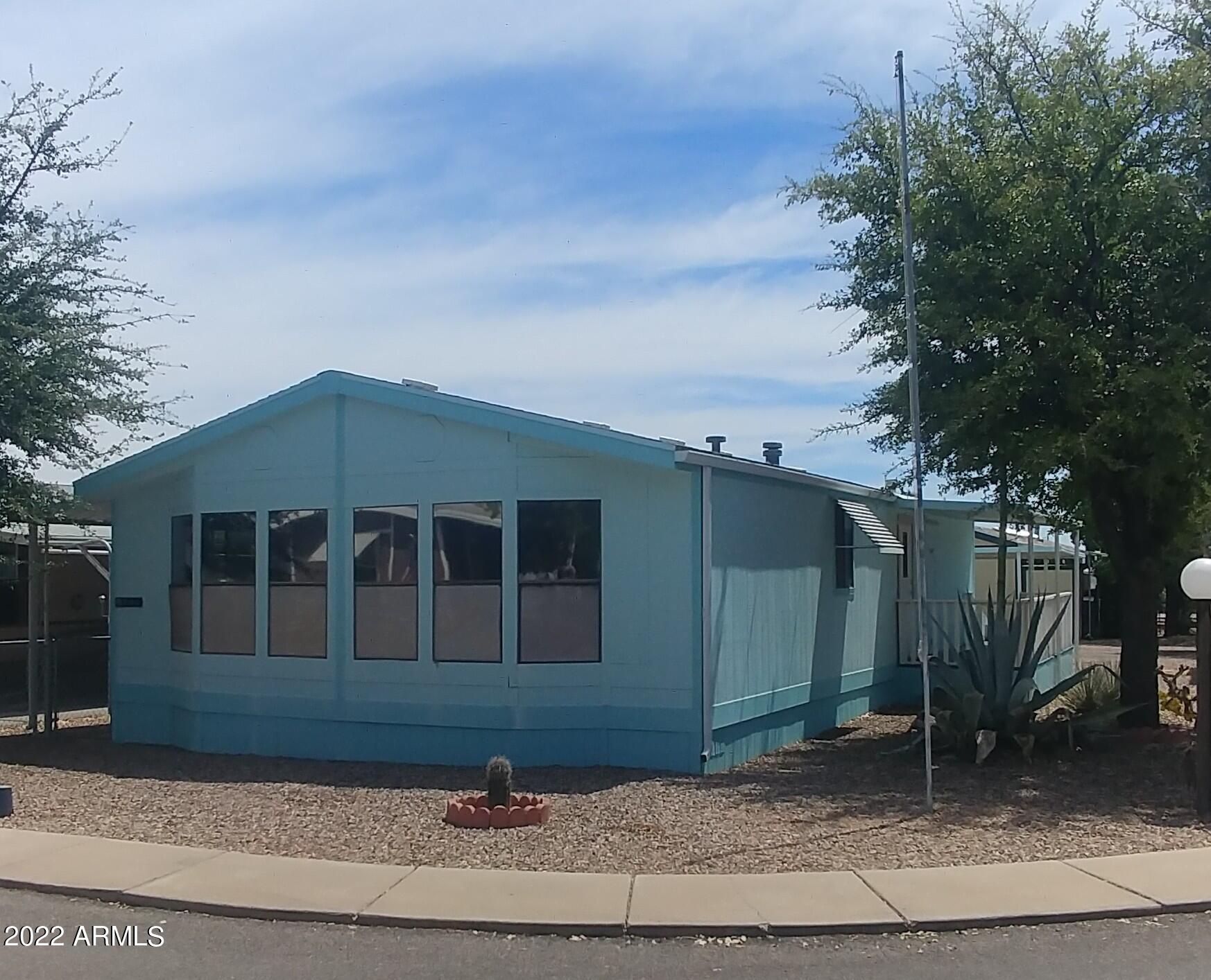 2 bedroom, 2 bath, open living room with many windows  to let the light in!  Laminate flooring in living areas and hall. Nice sized walk in closet in Master bedroom. Good storage in kitchen, large utility room with room for upright freezer or more storage. Corner lot includes a one car enclosed garage (approximately 12x20) and an additional storage building. Sierra Vista Village offers a gated community. 2 club houses. 2 swimming pools, one is an inside pool. Spa, laundry, exercise room, library, children's play ground. Gates open from 6:00AM to 6:00PM. Lot rent includes water, sewer, trash and cable.