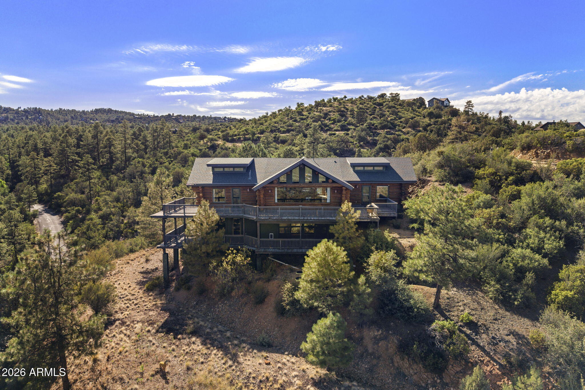 Wake up each morning to unobstructed views of Prescott's iconic Thumb Butte framed perfectly by dramatic floor-to-ceiling windows in this breathtaking Prescott Pines A-Frame retreat.

Designed to bring the outdoors in, the heart of the home is an extraordinary chef's kitchen positioned center stage to capture the panoramic mountain views. An oversized island invites gathering, while premium appliances, including a Viking range, make entertaining effortless. The kitchen flows seamlessly into the great room, where soaring ceilings and walls of glass create a stunning backdrop for everyday living. Upon entering the main level, you're welcomed by a cozy seating area that leads into the open-concept great room and the first of two expansive wraparound decks, perfectly positioned to take in spectacular sunrises and the surrounding natural beauty. Two spacious bedrooms are located on this floor, each featuring its own private bath, direct deck access, and unobstructed mountain views.
The lower level offers even more room to relax and entertain with a generous flex space ideal for a media room, game room, or second living area. You'll also find an additional bedroom, two storage rooms, and access to the second wraparound deck where you can soak in the peaceful mountain setting.

Whether you're searching for the ultimate holiday getaway, a place to host unforgettable family retreats, or an exceptional short-term rental opportunity, this one-of-a-kind A-Frame offers the perfect blend of luxury, comfort, and nature.

Because living like this with front-row views of Thumb Butte and sunrises that never get old isn't just a vacation. It's a lifestyle.