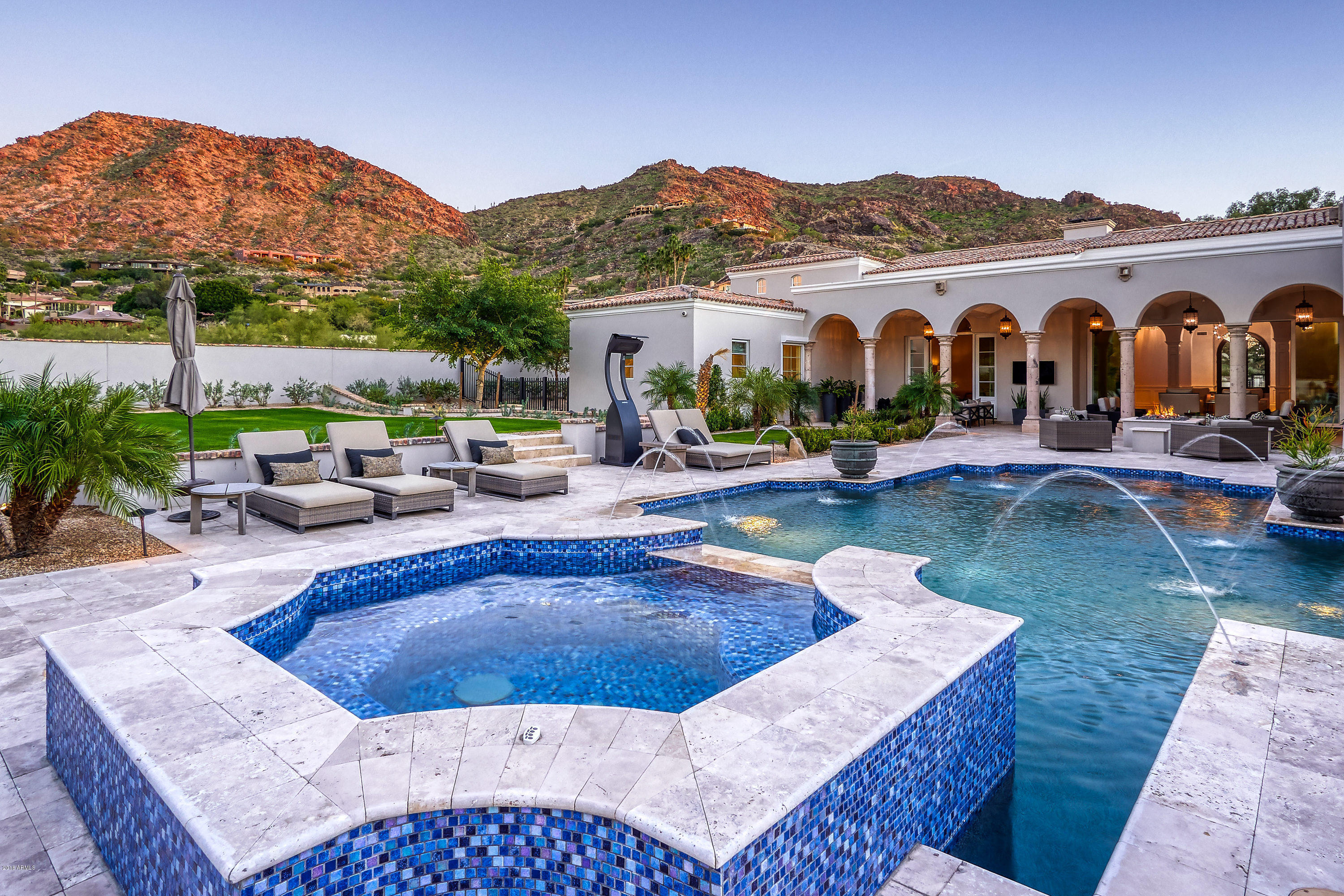 Located on one of the best streets in Paradise Valley this custom home designed by Mark Candeleria is exquisite. This near new masterpiece has impeccable craftsmanship and a spacious, livable floor plan.  Impressive entry door opens to formal living/ dining room and sliding wall of windows with pool/spa/firepit/ and fireplace all viewable to bring the outdoors in. The interior features beautiful white marble floors from the Greek Island of Thassos along w/limestone, marble & onyx counter tops, hand-carved groin vaulted ceilings, custom cabinetry throughout, mahogany library/office & lavish master suite. Amazing custom theater by Theater X, separate guest house, six fireplaces & lush grounds multiple grass areas, front courtyard, & tons of outdoor patios. This home is impeccable & turn key!
