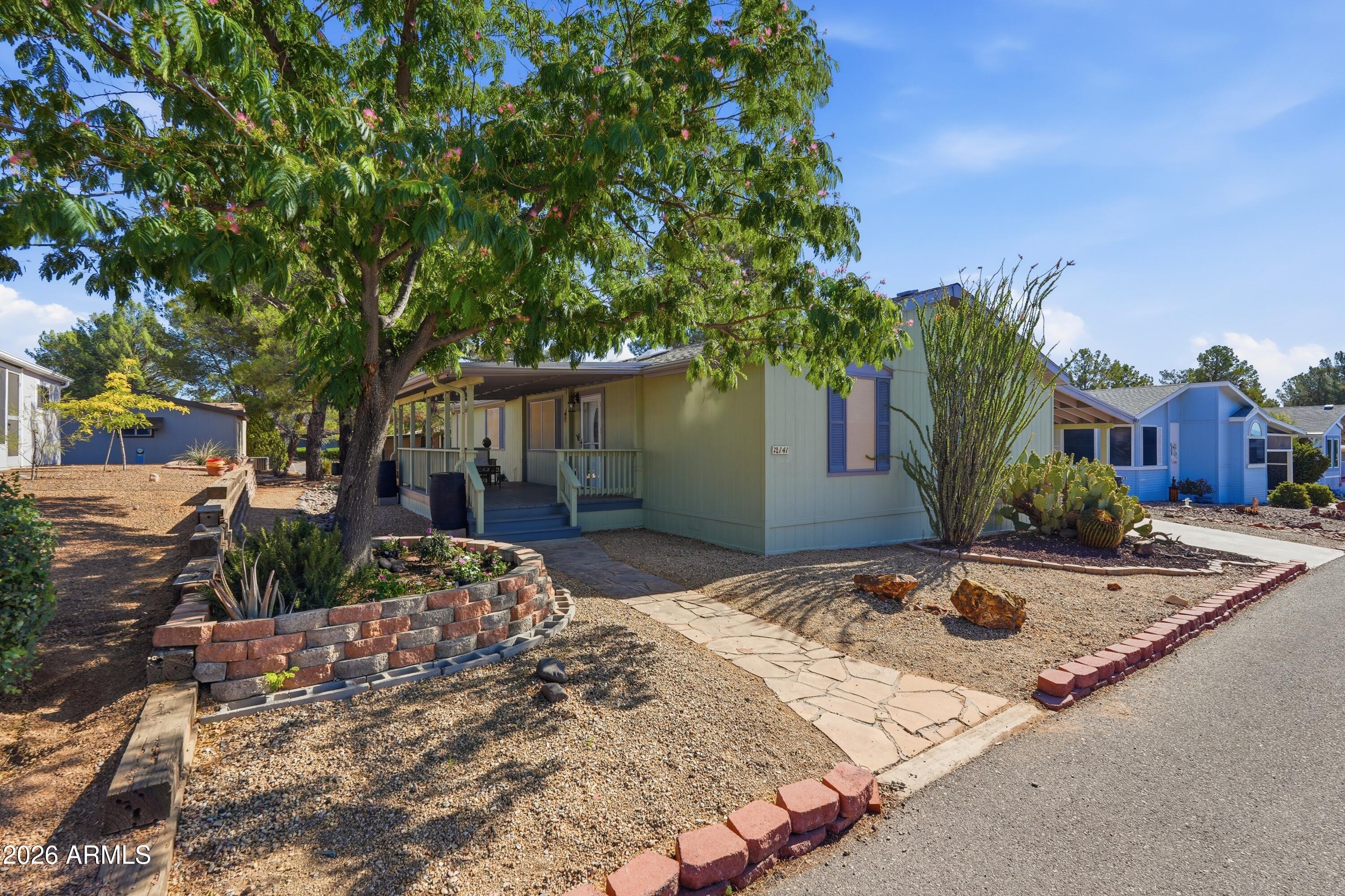 This spacious and bright home has been lovingly updated over the years and has so many bonuses to offer, including a large primary with ensuite bath and a custom kitchen remodel. The open concept kitchen showcases a gas stove and butcher block island with built in ventilation. Outdoors features a large covered deck, gutters with water catchment system, drip irrigation, extended carport, screened in side entrance with ramp for convenient accessibility, and large workshop. Located on a quiet street, on leased land, in the 55+ Pine Shadows Mobile Home park. Mature trees and gorgeous mountain views make this community a desirable place to call home. Situated along the Coyote Trails Golf Course, Pine Shadows provides top notch amenities for it's residents including a clubhouse and indoor pool. Updated 3 Bedroom 2 Bath w/Den in Crown Jewel of 55+ Communities:

*Central heat & air
*Vaulted Ceilings
*6 Ceiling Fans
*4 Sky Lights
*Gas Range w/Down-draft
*Microwave w/Convection
*Dryer in laundry room 
*Dual Glazed windows
*6 inch thick exterior walls 
*Handicap Ramp
*Parking for up to 3 Cars

3 Bonus spaces behind Carport
-Arizona Room w/ramp: 13x20
-Work Shop w/slop sink: 127 sq'
-Back Shop: 13x13

Pine Shadows is crown jewel of 55+ gated communities with calendar of events that provides many opportunities to meet people. 

PINE SHADOWS AMENITIES:
*Gated entry
*Golf Course (flanked by forest.)
*Banquet Room
*Community Room
*BBQ
*Billiards
*Clubhouse
*Library
*Curbside Garbage 
*Fitness Center
*Game Room
*Dog park (pets welcome)
*Picnic Area
*Shuffleboard
*Spa
*Swimming Pool
*Pickleball
*Tennis courts
*Calendar of Events
*Weekly Activities

The deck is a wonderful space to sit and enjoy the day.
Front porch features pin lights that turn on automatically at dusk.
The lush mimosa tree in front yard & garden, both on a drip irrigation system.