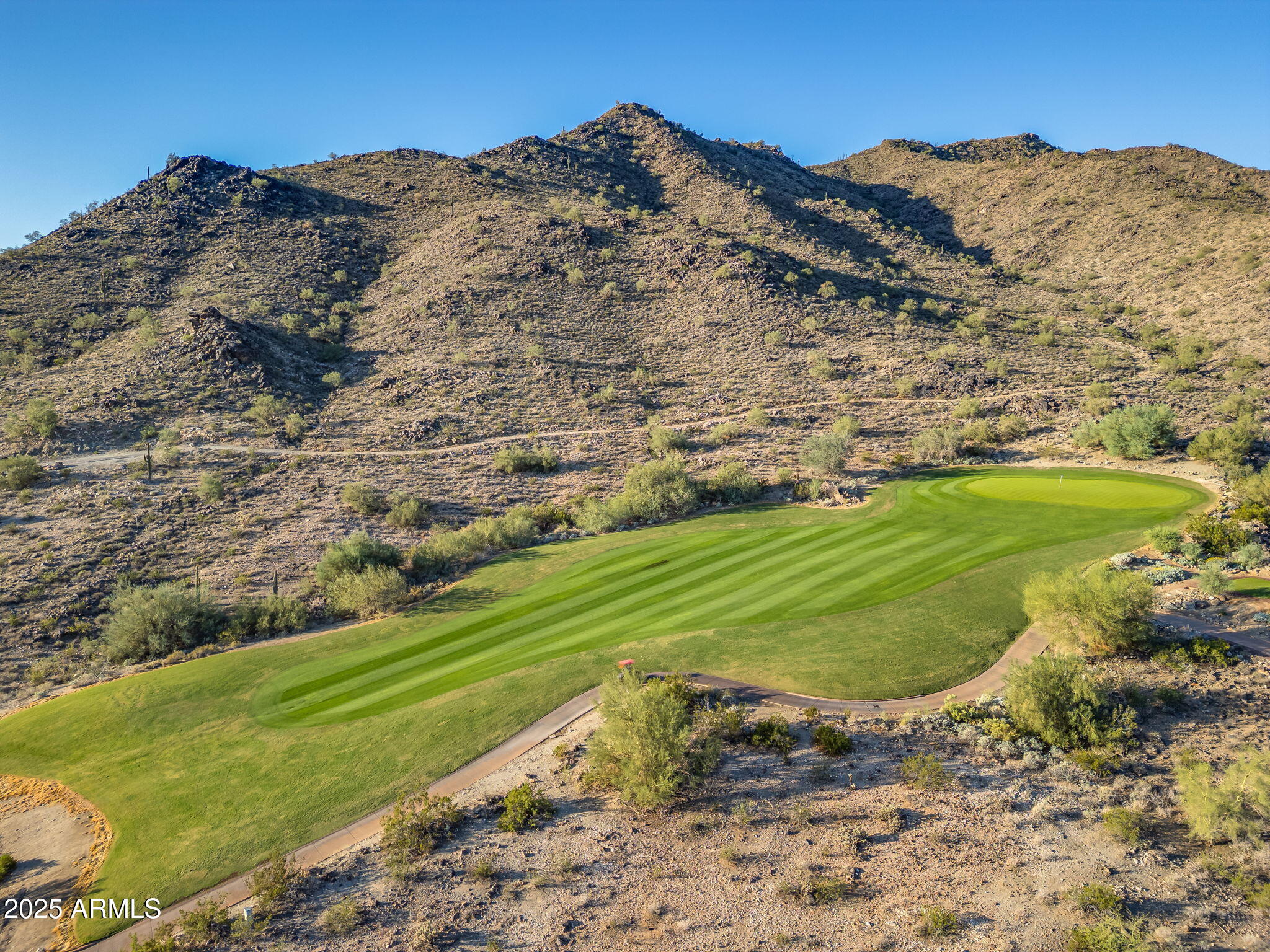 Spectacular mountain, city & golf course views!!  Your dream home on this homesite will be able to sit in the shade of the mountains & view the beautiful Arizona sunsets without the direct glare of the sun.  The property sits well back from the 13th fairway which slopes up the mountain to the green.  Beyond the fairway and green has the view of a spectacularly rising mountain, giving you fabulous daylight views.  City light views will enhance your night vision.  This home sits in a 3 hole loop of the Verrado Founders golf course for a short evening walk. All the homes surrounding this lot are built.  Thus you will not have to endure construction noise and debris next door.  Plenty of nearby desert wildlife to include Mule deer for your morning coffee, Zen moments.