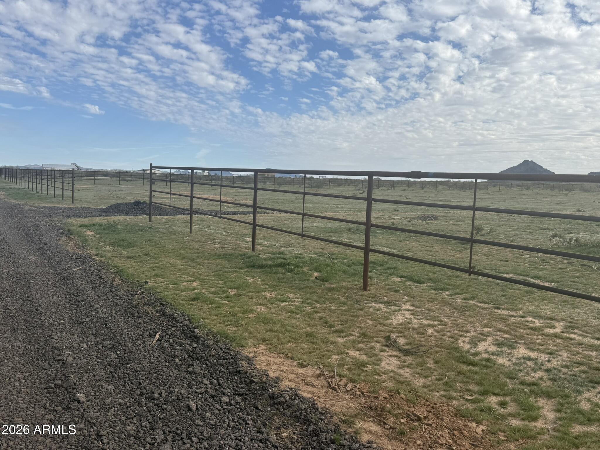 This pipe fenced 5-acre parcel is a builder's dream and a rare opportunity to own prime horse property with views of Eagle Eye Mountain. This land offers easy access and is ideally situated near local roping arenas, making it perfect for roping enthusiasts. The property is ready to build on with level ground, electricity close by, and Aguila Water easily available. Whether you're looking to build your dream home, a custom ranch, roping facility, or an investment property, this land offers the ideal canvas. This parcel is one of three lots currently listed for sale, offering flexibility for buyers who may want additional acreage. With its level terrain, convenient location, and exceptional mountain views, this parcel is an outstanding choice for anyone looking to enjoy the best of Arizona!
