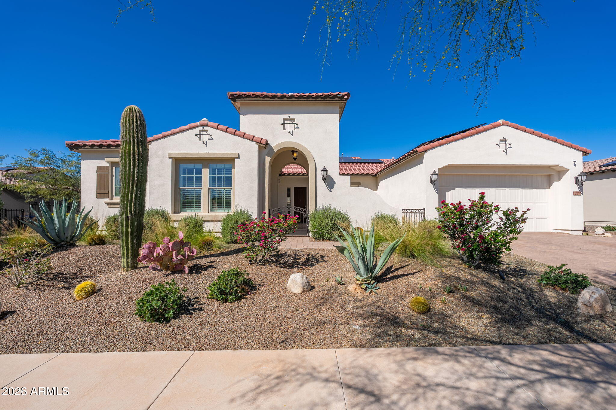 Welcome to this stunning home in the highly sought-after Victory at Verrado community, offering luxury living with breathtaking golf course and mountain views. Built by David Weekley Homes, this beautifully designed residence blends elegant finishes, thoughtful design, and exceptional indoor-outdoor living. A private gated front courtyard creates a warm and inviting entry, perfect for relaxing or entertaining. Inside, the home features a spacious open-concept layout filled with natural light and luxury wood-look tile flooring throughout, creating a cohesive and sophisticated feel while offering durability and easy maintenance. The chef's kitchen is the centerpiece of the home, showcasing a massive granite island, stainless steel appliances, and a 5-burner gas cooktop, offering both functionality and style for everyday living and entertaining. 

The home features two primary bedroom suites, each with its own spa-inspired en-suite bathroom including dual vanities with quartz countertops, separate soaking tubs and showers, and generous walk-in closets. A separate den/office provides flexible space for work, hobbies, or additional living needs.

Step outside to a resort-style backyard that backs directly to the 13th hole of the Victory Course at Verrado Golf Club, offering stunning golf course and mountain views. The outdoor space is designed for year-round enjoyment and features an extended covered patio with ceiling fans and remote-controlled sunshades, along with a private heated pool and attached heated spa complete with a Baja shelf and water feature, creating the perfect outdoor retreat.

Additional highlights include a 3-car tandem garage with epoxy flooring and built-in cabinetry, providing ample storage and workspace.

This exceptional home combines luxury finishes, thoughtful design, and a premier golf course setting in one of Buckeye's most desirable communities.