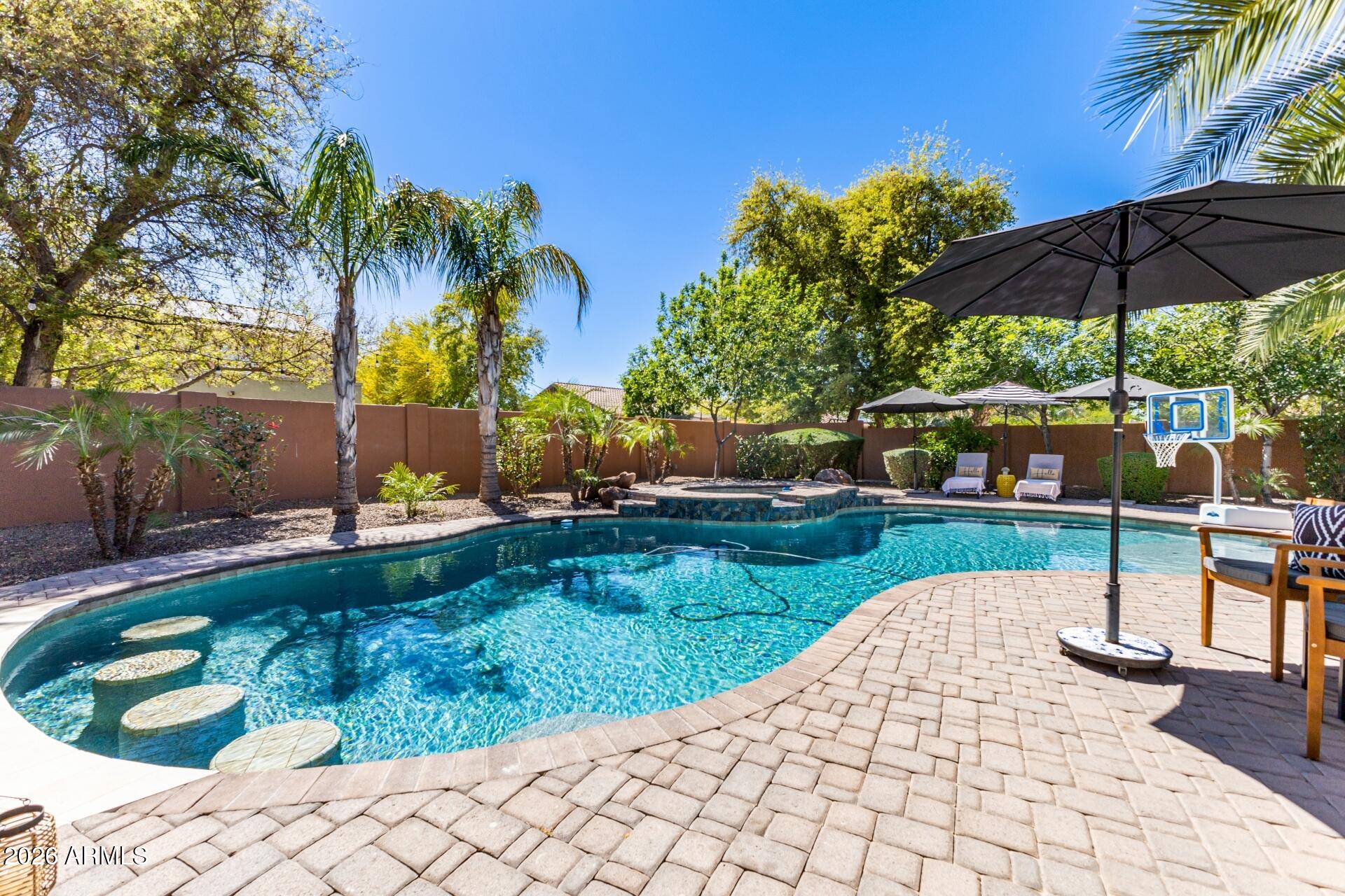 Rare opportunity to own a basement home on a ½ acre lot with a resort-style backyard designed for year-round Arizona living. This impressive 4,700 sq ft home offers 4 bedrooms, an office, and 3.5 baths with a layout built for both everyday living and entertaining. 
The finished basement adds incredible flexibility, ideal for a media room, game room, fitness space, or additional living area. A private guest suite at the front of the home includes its own den, bedroom, and full bath, perfect for multigenerational living or extended stays. An enclosed office provides a dedicated work-from-home setup.
Upgrades throughout include custom Classy Closets in the bedrooms, a Stone Creek-designed office, a 3-panel sliding glass patio door, and a custom Porter Barn feature wall leading to the baseme nt.  Epoxy flooring, and the property also includes an RV gate for additional parking and convenience. Step outside to a true resort-style backyard designed for entertaining, featuring a heated pool and spa, swim-up bar, sunken ramada with a built-in gas grill and dual mounted TVs, putting green, basketball court, misting system, and a gas fireplace. A louvered, motorized covered patio completes the space, creating the ultimate Arizona indoor-outdoor lifestyle. See the documents tab for a full list of upgrades and features.