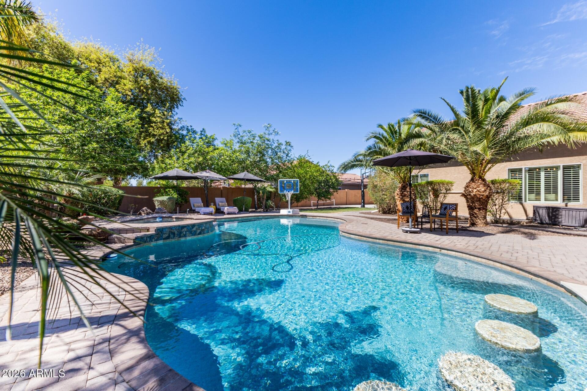 Rare opportunity to own a basement home on a ½ acre lot with a resort-style backyard designed for year-round Arizona living. This impressive 4,700 sq ft home offers 4 bedrooms, an office, and 3.5 baths with a layout built for both everyday living and entertaining. 
The finished basement adds incredible flexibility, ideal for a media room, game room, fitness space, or additional living area. A private guest suite at the front of the home includes its own den, bedroom, and full bath, perfect for multigenerational living or extended stays. An enclosed office provides a dedicated work-from-home setup.
Upgrades throughout include custom Classy Closets in the bedrooms, a Stone Creek-designed office, a 3-panel sliding glass patio door, and a custom Porter Barn feature wall leading to the baseme nt.  Epoxy flooring, and the property also includes an RV gate for additional parking and convenience. Step outside to a true resort-style backyard designed for entertaining, featuring a heated pool and spa, swim-up bar, sunken ramada with a built-in gas grill and dual mounted TVs, putting green, basketball court, misting system, and a gas fireplace. A louvered, motorized covered patio completes the space, creating the ultimate Arizona indoor-outdoor lifestyle. See the documents tab for a full list of upgrades and features.