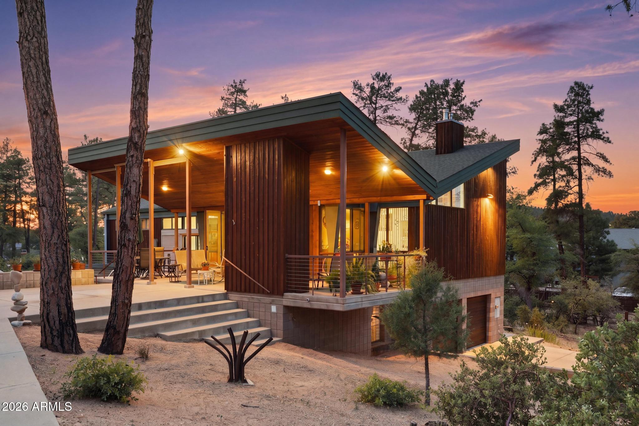 A rare opportunity to own a cabin in the woods in Payson, designed and built as his personal residence by former Dean of Architecture at the University of Arizona and award-winning architect, Robert Hershberger. Set on a private 2/3-acre lot surrounded by mature ponderosa pines, this home reflects Frank Lloyd Wright-inspired organic architecture where design, light, and landscape are intentionally connected.  The architect describes the home as a 'flower in the forest,'' with two major rooflines sloping upward to the north and south like petals to capture sunlight and direct rainwater into lower-level cisterns (the roots), while the central greenhouse (the stamen) supports plant life and light within the home. Very large high windows on each side of a gas fireplace greet those entering the home, along with spectacular views of ponderosa pines and the ever-changing skyline. Each room on the main level features high windows, framing a unique view of the forest, while skylights and interior glass bring natural light deeper into the home. A central greenhouse atrium serves as a transition from the south-facing covered porch into the house, connecting indoor and outdoor living. The great room combines living, dining, and kitchen spaces with custom birch cabinetry and aspen tongue-and-groove ceilings. The main level includes the primary suite with separate closets, along with a study, powder room, and pantry. The lower level includes two guest bedrooms, a full bath, and a very large recreation room. This room features a built-in pool table with storage beneath and could serve as a third bedroom with its three closets. Additional lower-level spaces include storage rooms, mechanical rooms, and two dedicated cistern rooms. Outdoor spaces include a south-facing covered porch designed for year-round use, a walled garden for protection from wildlife, and terraces and pathways that follow the natural contours of the land. A two-car garage and additional driveway parking provide ample guest parking.  Solar panels provide supplemental energy efficiency and support the home's long-term sustainability.  This is not simply a home - it is a rare architectural expression where nature, structure, and design are fully integrated, offering a one-of-a-kind living experience in the forest.  This listing is for the house only which is on lot 135.  Lot 134 is being sold separately for $125,000.
