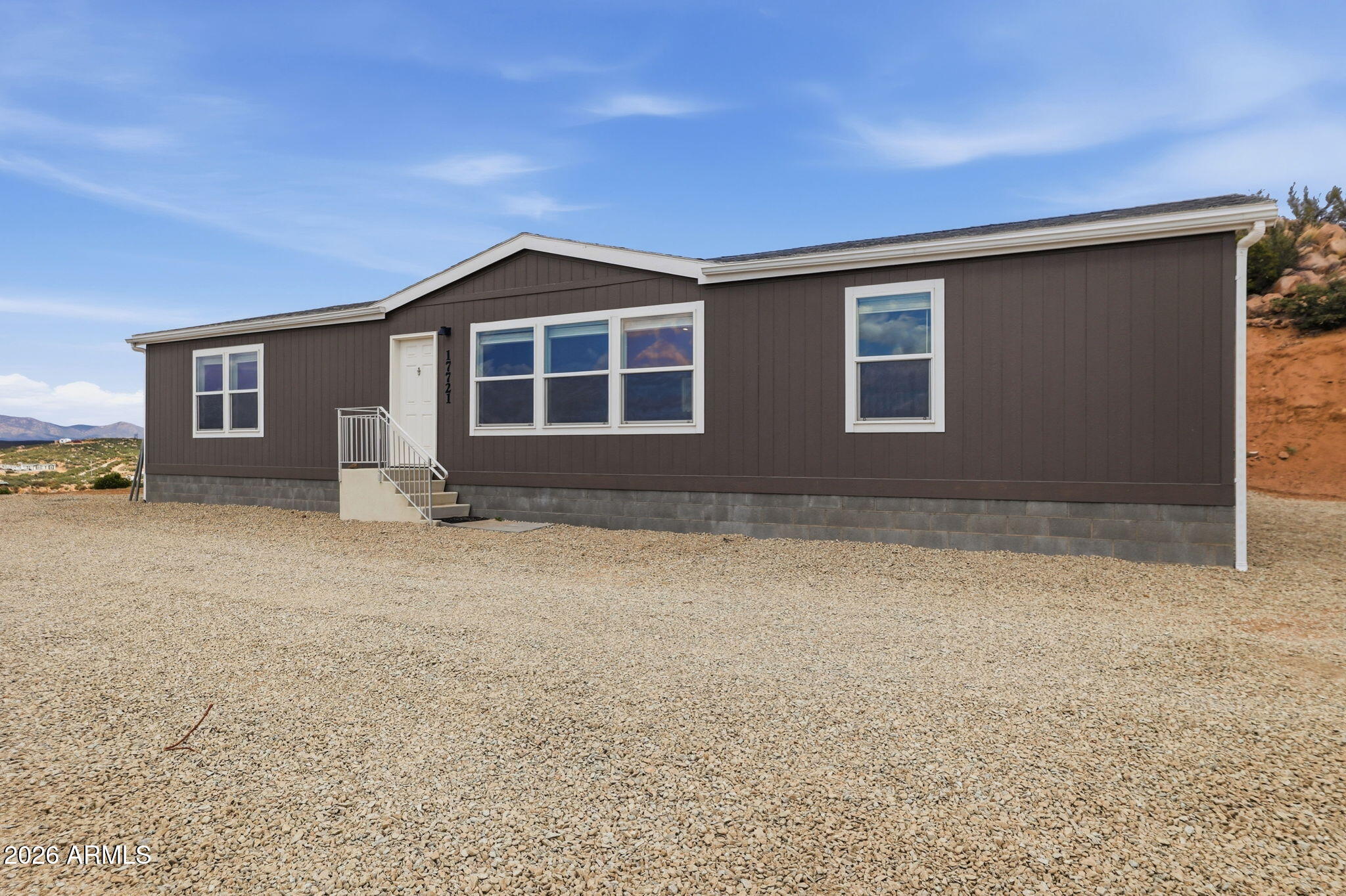 Perched on top of the mountain, this manufactured home with incredible views offers the perfect blend of comfort, style, and convenience. Featuring an open floor plan, this move-in ready home is filled with natural light and showcases breathtaking scenery through the large living room windows. The spacious kitchen includes stainless steel appliances, a large island, and hidden pantry storage behind cabinet doors. Additional highlights include a laundry room, energy-efficient 2x6 construction, and easy access to I-17 for a convenient commute. Enjoy mountain living, panoramic views, and the peaceful setting this beautiful Arizona home has to offer. Perfect for buyers searching for a view home, open concept manufactured home, and home with scenic views.