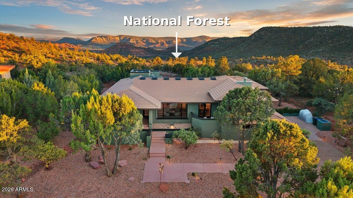 At the top of the exclusive gated community of Foothills South, where West Sedona gives way to open sky and National Forest, sits a serene desert retreat where you can walk from your backyard directly out to the famous red rocks and endless miles of world-class hiking.  Welcome to 89 Linda Vista - a beautifully remodeled 3,752 sq. ft., 4-bedroom+study, 3-bath home where every finish, every material, every detail speaks the language of contemporary luxury. Warm organic tones and designer fixtures blend seamlessly with a perfectly curated, luxurious interior - furnishings available with an acceptable offer, making it possible to simply arrive and begin living the Sedona lifestyle you've been dreaming of. This is a home that brings the outside in while providing comfort and luxury at every turn. Oversized picture windows throughout frame the surrounding National Forest and red rock views. A cohesive design theme carries through every room - white oak luxury vinyl plank floors flow through the living areas and bedrooms, architectural lighting lifts the eye to elevated ceilings while casting an ambient warmth, and Taj Mahal quartzite countertops - with their soft, creamy white base and delicate golden veining - weave a seamless thread from the kitchen through all three baths.

The home's multiple entertaining areas are connected by a gallery hallway, illuminated by a row of skylights that flood the space with natural light by day and open up to Sedona's star-filled night sky after dark.

The chef's kitchen offers an abundance of gleaming Taj Mahal quartzite countertops in a highly functional layout made for both cooking and entertaining. An oversized picture window frames the National Forest beyond, with hummingbirds stopping by just outside to say hello.

Tucked in its own wing of the home, the primary suite is a private spa retreat in every sense - featuring a built-in sauna, an outdoor hot tub, and a cold plunge just steps away. The same warm, organic finishes and brushed bronze accents that flow throughout the home carry seamlessly into this space, with a level of finish that rivals any luxury hotel. Just off the primary suite, a versatile flex space -- ideal as a study, exercise room, or hobby room - shares a two-sided fireplace with the suite, making it as cozy as it is functional.

The opposite wing of the home features a guest bedroom with its own ensuite, a study, and two additional guest rooms that share a bath. Six seasonal decks are positioned throughout the home, including an upper deck with 360-degree views of Sedona's most iconic red rock formations.

The rear yard is a nature lover's paradise. Flagstone patios and walkways meander through native piñon pines and junipers, with views stretching for miles across National Forest to Sedona's iconic Cathedral Rock. Outdoor cooking here, nestled among native piñon and juniper with the occasional wildlife sighting, is the perfect way to end the day.

89 Linda Vista sits on one of the most desirable streets in one of Sedona's most sought-after gated neighborhoods. This half-acre parcel backs directly to National Forest, with immediate trail access to Skywalker Trail and Sedona's 300+ miles of hiking. Thousands of acres of protected land right out your back door - privacy here is absolute. Come and experience this special property for yourself.

FEATURES OF NOTE: 

INTERIOR:
New interior paint throughout
Taj Mahal Quartzite countertops throughout (kitchen, bathrooms, and laundry room)
All new kitchen appliances
Soft close cabinets and drawers throughout kitchen
Three full bathroom remodels
New ceiling fans throughout and updated light fixtures
Primary bathroom sauna addition
New cold plunge
New Luxury Vinyl Plank flooring throughout
New ADT system
Hot tub
Hot water recirculating system
Water softener with reverse osmosis
Whole house vacuum 

EXTERIOR:
New metal pergola
 New brick paver pathway
 New full exterior paint
 New updated outdoor and exterior landscape lighting
 All new landscaping in the front yard and backyard
Roof: all new skylights and flat roof sealant, both under warranty (see SPDS)
Electric car charger in garage
Energy-efficient solar system, prepaid up to 2032