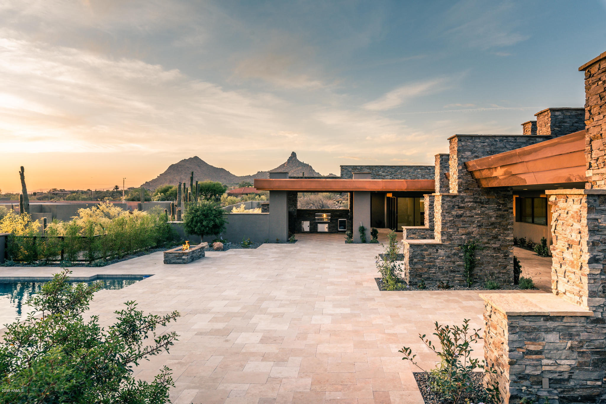 A Red Moon Homes ''new build'' just completed! Dramatic stone step architectural features, multiple roof lines with clerestory windows and organic materials -- metal, glass, wood and stone -- unite to create this unique desert contemporary.  Split, single-level floor plan offers expansive living areas indoors and out. Sitting on a 1.66-acre  Glenn Moor lot, this oasis provides mountain, sunset and city light views, privacy and relaxed desert living.