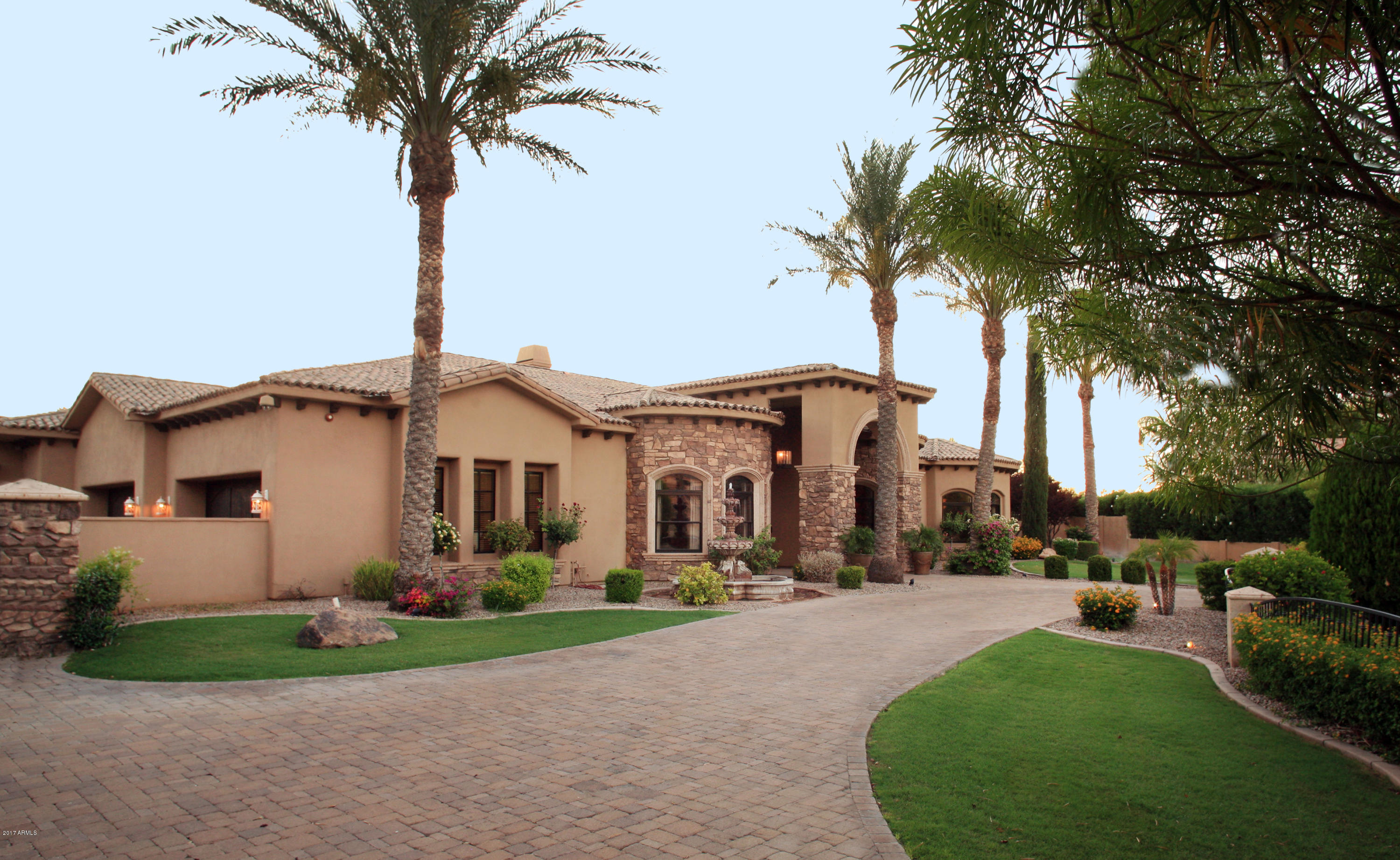 Private Paradise Valley estate that backs to the wash and located in a quiet cul-de-sac. There are 5 bedrooms plus a den/library, formal living and dining, gourmet kitchen, game room with wet bar and wine cellar, family room and theater. The current owners added on to the master suite creating a larger closet, message room, exercise room and nursery (this area could be easily changed to create a larger single area). The four car garage has a gated motor court and plenty of area for outside parking. Enjoy the back yard amenities that include a large covered patio with misters and built-in BBQ, heated pool and spa, a vegetable garden area and a large grass play area for the family and kids. The sunset and mountain views are just an added bonus to this great property.