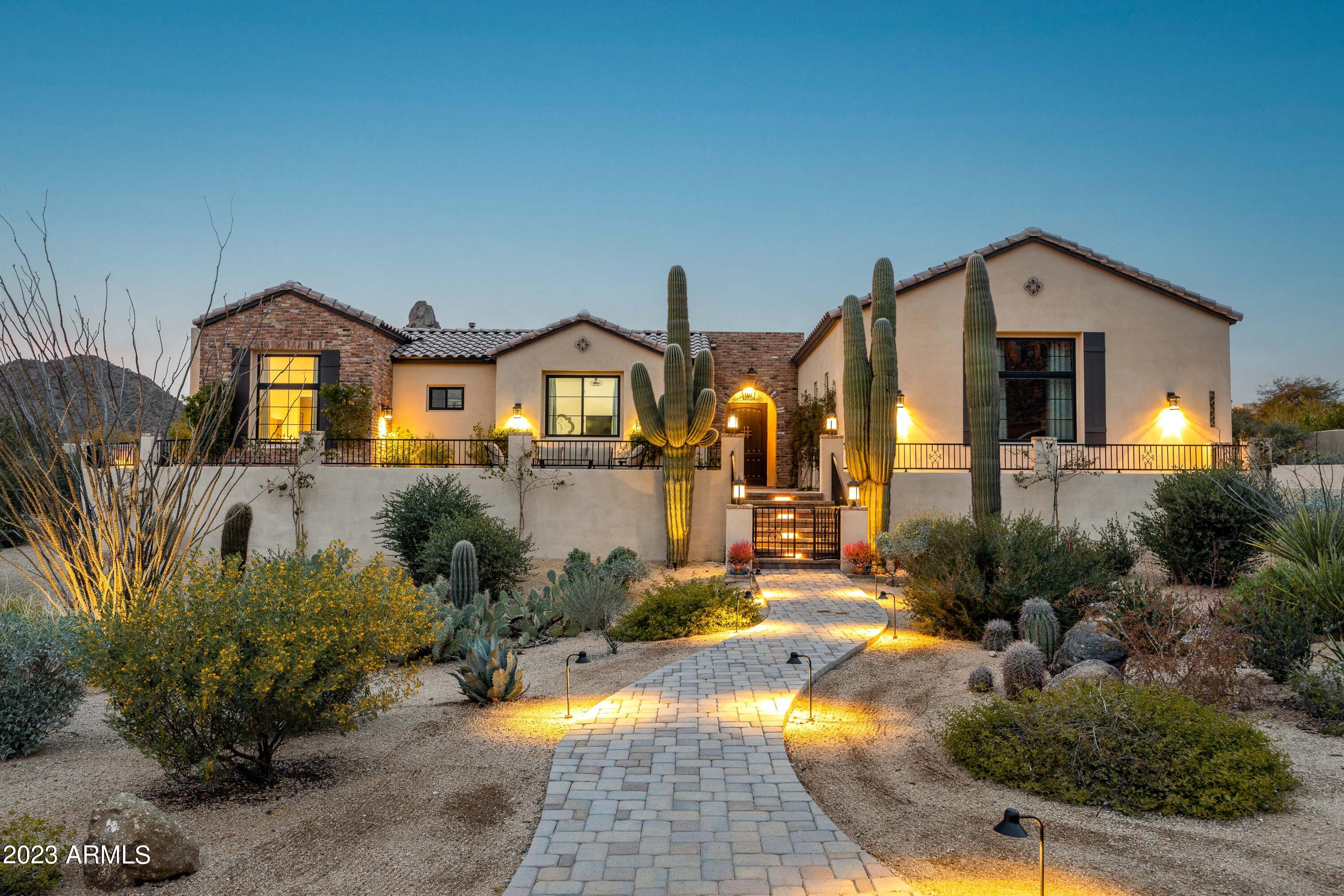 This 2021 custom-built modern farmhouse in Troon Fairways of North Scottsdale is nestled between Troon Mountain and Pinnacle Peak, inspiring instant enjoyment in this resort style home. A private courtyard entry with firepit and outdoor TV (with automated LED lighting shade) welcomes you to this stunning home featuring 4 bedrooms, 4 bathrooms (plus 2 half bathrooms), an attached guest house, media room or flex space, media room, utility hobby room, office, resort style pool with sun bench, heated spa, stone travertine, natural boulder water feature and even an outdoor shower. The single level home, without a single interior stair, also features automated window shades, Pella doors and windows, a Savant AV system, Sonos throughout, an outdoor living space with 15-foot retractable doors, Infratech patio heaters, remote control sun shades, firepit, outdoor kitchen with gas barbecue, smoker and built-in refrigerator, roof-top deck with astounding 360-degree views, pool and spa, outdoor shower, and even more. The kitchen boasts Ljen Blue Quartzite countertops with dual-side kitchen bar, Bosch built-in coffee maker, Brizo fixtures, and multiple beverage and wine storage. Not to be overlooked, this incredible retreat has an oversized 3 car garage including overhead rack storage, custom cabinets and utility sink. Surrounded by views of Troon Mountain and Pinnacle Peak, this incredible home was built by Keith Brous Hawk Builders, renowned for quality craftsmanship and service in the valley.