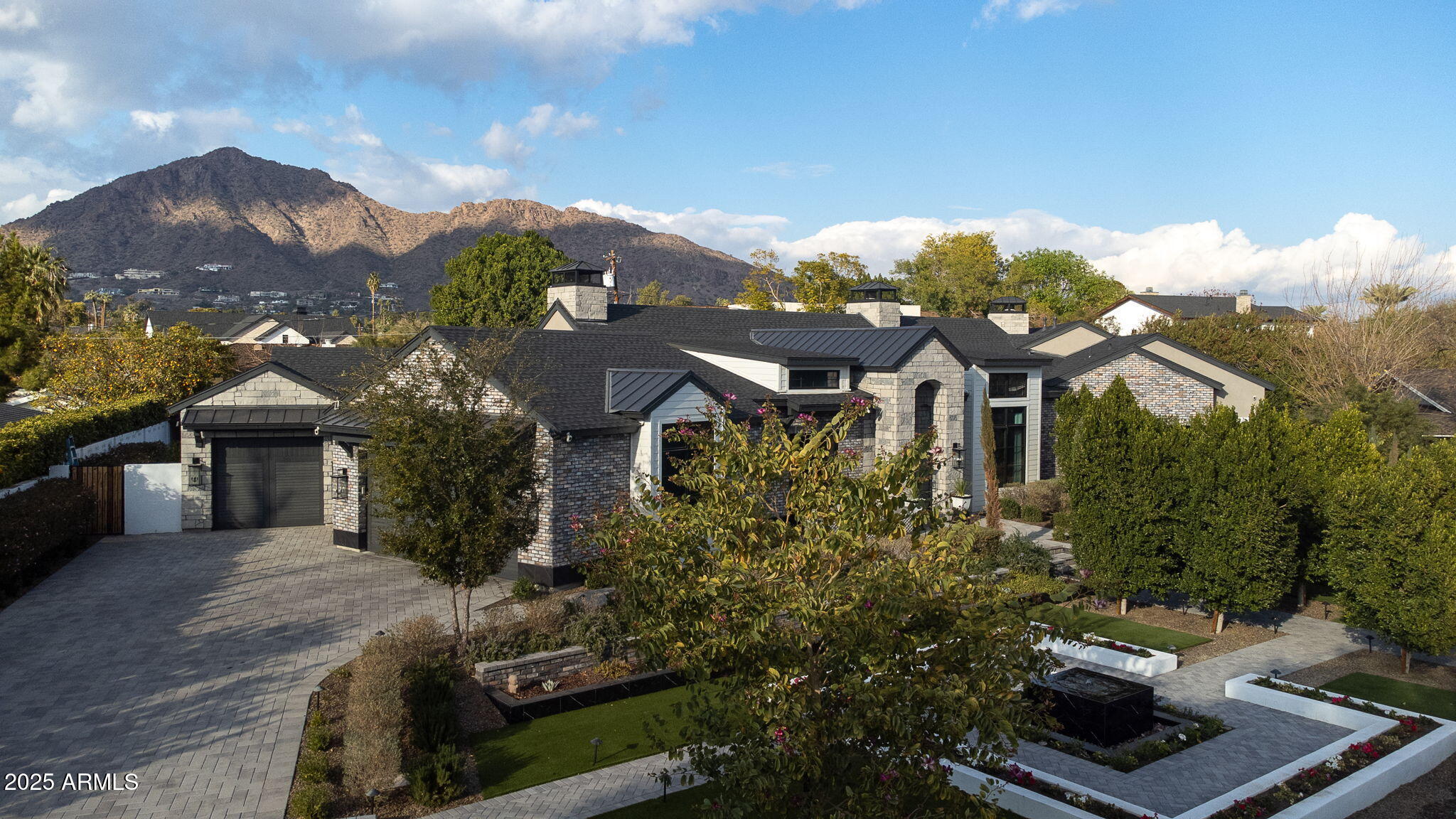 Tucked in a cul-de-sac in Arcadia, this modern Italian farmhouse, built in 2020, offers luxury and comfort. With extensive investment in mature landscaping, the home's lush surroundings complement its elegant design. A steel Dutch door and barrel-vaulted ceiling lead to a refined interior with soaring ceilings, glazed white oak cabinetry, and Venetian plaster fireplaces. The open floor plan features a grand great room with a sliding glass wall, a formal dining area with a wine display, and a lofted flex space. All bedrooms are master suites, plus there is a stunning primary master bedroom. Outside, an extended travertine patio, heated pool, jacuzzi, and Camelback Mountain views create a serene retreat. Steps from top schools, dining, and nightlife—schedule your tour today!