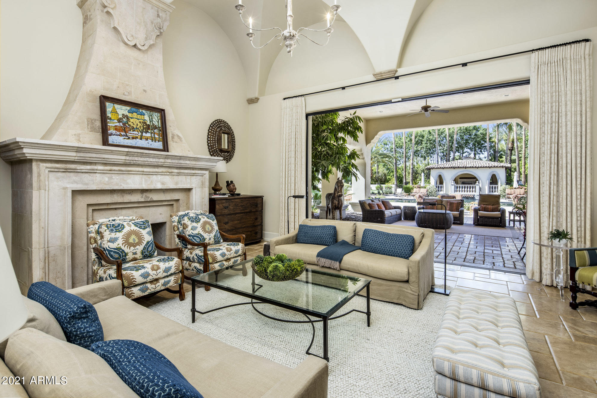 The exclusive guard gated community of Judson Place sets the stage for this timeless home offering the highest standard of quality, design and craftsmanship. This incredible home is bright, fresh, and sophisticated. It features 5 bedrooms, 8 baths, office, steam shower, sauna, wine room, movie theatre, and a resort style backyard with water and fire features, a saltwater pool and spa, a putting green, and a sports court. MORE...LOTS MORE... ...The architecture includes soaring groin vaulted and barrel roll ceilings, comfortable pillow top travertine floors with wood runners and lovely inlaid tile at hallway intersections.
Beautiful ironwork, French doors, and decorative tile flooring welcome you to a groin vaulted foyer. The spacious living room, with stately fireplace and telescoping wall, opens to the resort style backyard.  Just around the corner are a large dining room, and walk in temperature-controlled wine room with barreled brick ceiling and iron scrolled glass door.
The heart of the home, the kitchen, has two islands, Subzero & Wolf appliances galore, breakfast table, desk, and barreled brick ceilings. It opens to the covered patio with vented grill for easy BBQ and to a large family room with a huge corner telescoping, battery operated glass doors that open to the back yard. A game room and bar are adjacent to the family room. 
A bright and sunny, airy office with bookshelves, window seats, and private bathroom.  Beautiful woodworking and groin vault ceilings make this office a place to work or recharge. 
The owner's bedroom is spacious with beautiful built ins and fireplace. A French door provides access to the backyard and heated salt-water spa.  An expansive bath, has two sinks, make up desk, two commodes, two large closets, tub and programmable steam shower. Just down the hall is an exercise room with sauna. Everything an owner would want. 
The secondary bedrooms are all ensuite and substantial in size.  A darling side patio with fountain separate two bedrooms as a welcoming, peaceful retreat.
The 8,800 sq ft. home also has a 900 sq ft guest house which is accessible from the front motor court. It provides a bright and open living area with full kitchen, bedroom and bath, well as side parking for a full separate guest experience. 
The expansive covered patio area, ramada with fireplace, pool and spa with water and fire features, pool bath, putting green and sports court, provide everything needed for entertaining and family time. This home truly set the standard for luxury when it was built and still checks all the boxes a buyer wants!