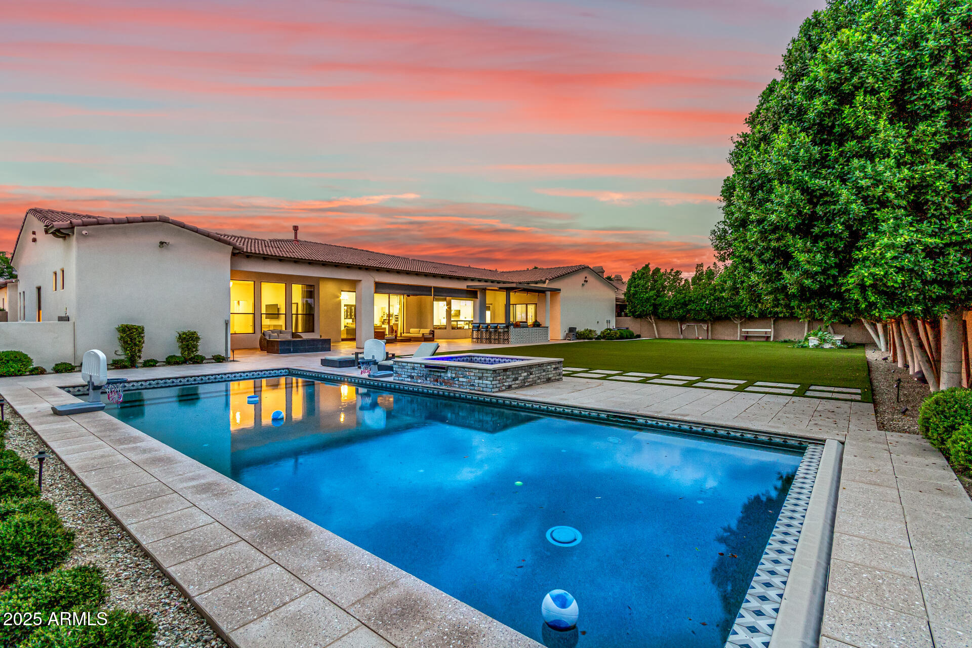 Your DREAM home is here! Set within the gates of prestigious Vasaro, this gorgeous residence is a masterclass in sophistication and resort-style living. Providing 5 large beds, 5 baths (all in suite baths & walk in closets) + den+ gameroom!!!! Front yard provides a circular paver driveway, excellent curb appeal, manicured landscape, and a 4-car garage w/ample cabinetry. The interior exudes elegance throughout with a grand foyer, 14' tall ceilings, stylish light fixtures, a neutral palette, abundant natural light, and wood-look tile flooring in all the right places. You'll love the formal dining room, designed for unforgettable gatherings! The spacious great room redefines luxury entertaining, complete with a sleek fireplace, pre-wired surround sound, a dry bar w/wine cooler, and..... multi-sliding doors that open to the back. The gourmet kitchen is nothing short of extraordinary High-end SS appliances, granite counters, a tile backsplash, white shaker cabinetry, a walk-in pantry, a center island, a breakfast area, and a large waterfall island make up the culinary space. For productivity, a double-door den with French doors to the front offers the perfect office or creative studio. The primary bedroom is a true sanctuary, opening to the outdoors and showcasing a spa-inspired ensuite with barn-door entry, soaking tub, dual vanities, oversized tiled shower, and a generous walk-in closet. Each secondary bedroom features its own walk-in closet, with two enjoying private baths and two sharing a stylish Jack & Jill. Entertainment abounds in the media room, thoughtfully designed with a state-of-the-art golf simulator for endless leisure at home. Laundry room with a sink & cabinetry. Out back, the resort vibe continues! Designed for ultimate relaxation and enjoyment with an extended covered patio w/ built-in BBQ & seating bar, and a cozy firepit (added in 2020). The sparkling pool and spa, putting green, lush turf, and mature trees complete this private outdoor sanctuary (all of these features added 2020). A property of this distinction is rare, where timeless elegance meets cutting-edge amenities, and every day feels like a five-star escape! See it! Love it! Love it!