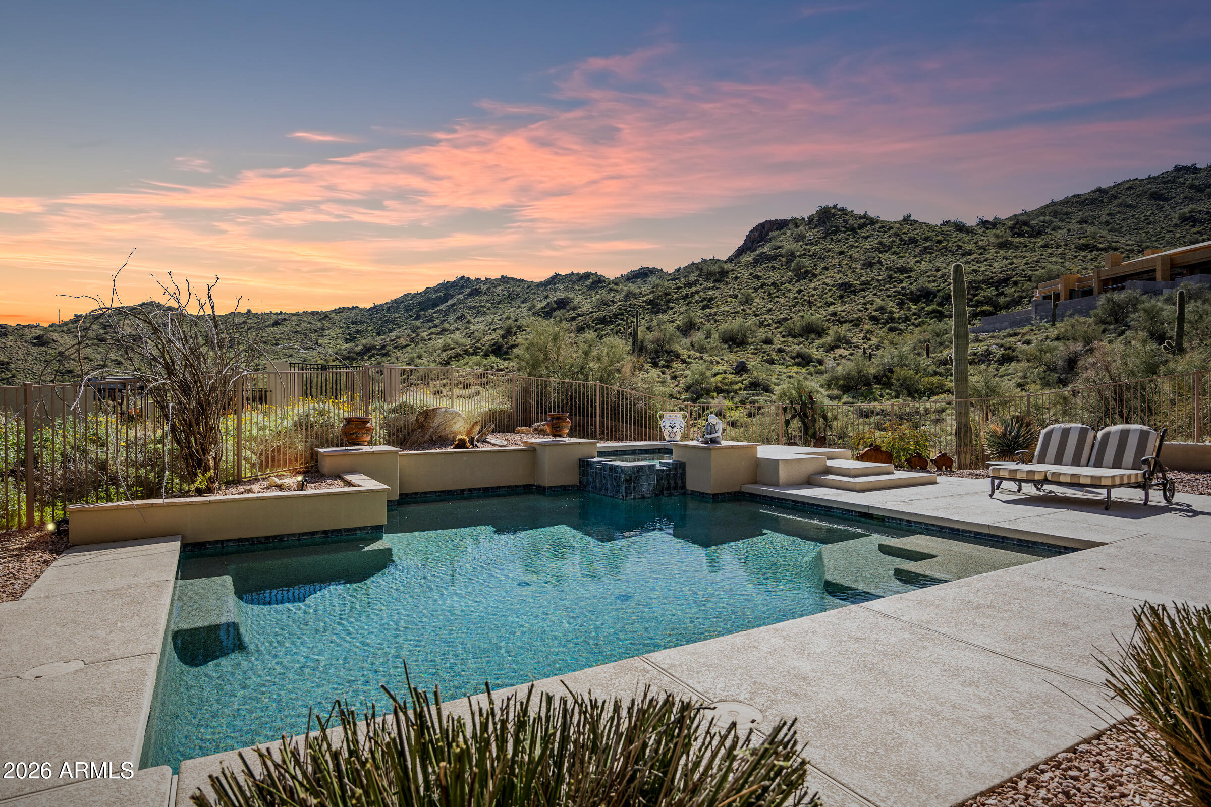 A luxury desert mountain retreat with sweeping, unobstructed views from nearly every room, nestled within the secluded, gated community of Shadow Canyon at Sunridge Canyon. A grand foyer opens into an expansive great room featuring tongue-and-groove beamed ceilings, custom textured walls, a floor-to-ceiling fireplace, formal dining area, and wet bar. Walls of glass frame the desert scenery and lead to a private outdoor oasis through a large sliding glass door. The gourmet kitchen is appointed with granite countertops, a generous center island with seating, knotty alder cabinetry, stainless steel appliances, a gas range, and a built-in pantry. The formal dining area captures desert views, with an adjacent sitting area designed for relaxation. The spacious primary suite offers... a fireplace, private patio and pool access, and a luxurious bath with a soaking tub, glass and natural stone snail shower, dual vanity, and large walk-in closet.

Three additional ensuite bedrooms each include walk-in closets, providing comfort and privacy. A designer powder room adds a striking custom touch.

An exterior spiral staircase leads to a rooftop deck with panoramic 360-degree views of mountains, city lights, and the Fountain Hills fountain. New elastomeric roof coating completed January 2026.

Oversized three-car garage with built-in cabinetry completes this exceptional home.