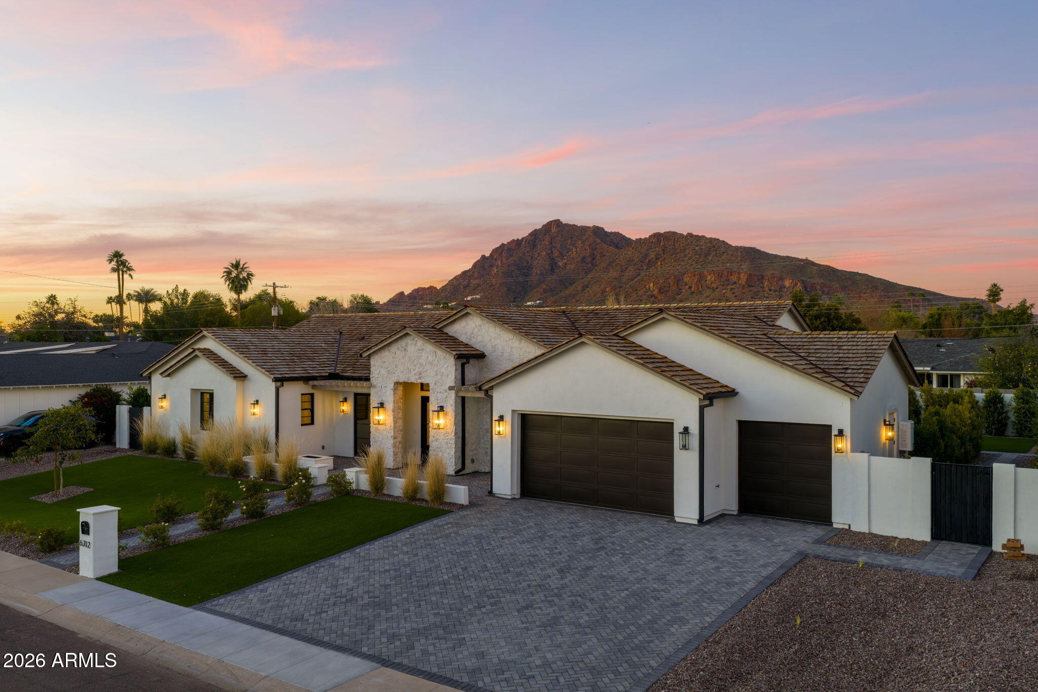 Experience the best of Arcadia Proper living in this newly constructed, coastal-inspired estate set against the backdrop of Camelback Mountain. Offering five bedrooms and six-and-a-half baths across 5,213 square feet on a generous one-third-acre lot, this thoughtfully designed home blends timeless style with modern comfort. Reclaimed French limestone fireplaces anchor both the family room and primary retreat, while the open-concept main level features a dedicated office, formal dining, gourmet kitchen, and inviting living spaces that flow seamlessly to a covered patio and resort-style pool—perfect for indoor-outdoor living. The lower level adds exceptional versatility with a spacious basement and two walkout patios, offering a game room, theater, gym, powder bath, wet bar, and full guest quarters. Ideal for hosting, multi-generational living, or creating a private retreat, this level is designed to adapt to a variety of lifestyles. A three-car garage provides ample storage for vehicles, a golf cart, bikes, and recreational equipment. With thoughtful planning, generous scale, and refined finishes throughout, this residence offers a rare combination of elegance, functionality, and livability in one of the area's most desirable settings.