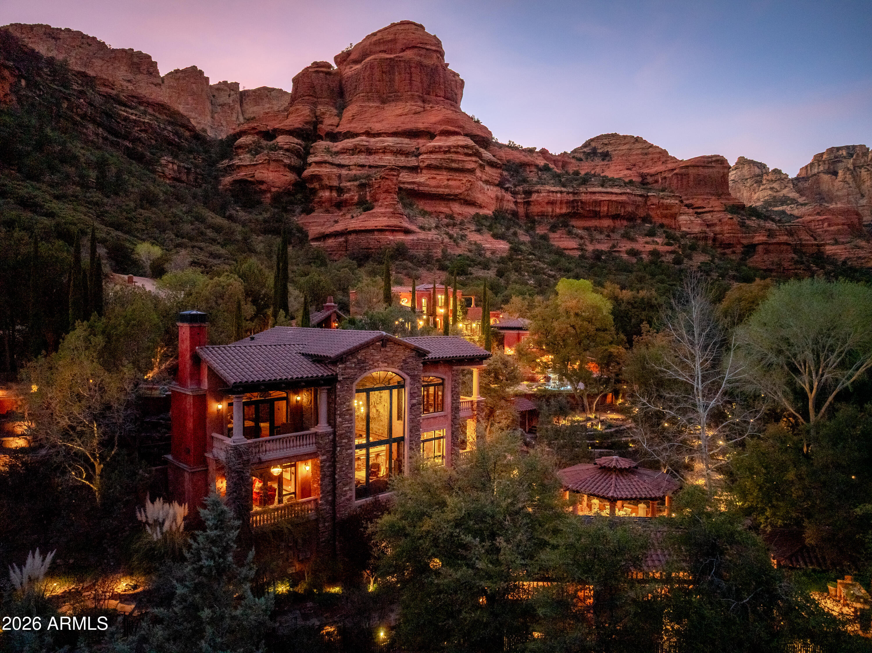 Behind the gated Enchantment Resort sits this rare, double lot luxury compound offering unmatched privacy, National Forest boundaries on three sides, and breathtaking Boynton Canyon red rock views. Designed as a legacy estate with Old World Mediterranean character, the property includes a 3,432 SF main residence plus 1 guest house and 2 guest casitas, a full private spa, multiple ramadas, and a park like event ready outdoor setting. Enjoy exclusive access to Enchantment Resort and award winning Mii Amo Spa amenities--fitness, pools, dining, tennis, and guided adventures. With its expansive wellness spaces, and meticulous craftsmanship, this one of a kind retreat is designed for gathering, restoration, and extraordinary living. Welcome to one of the most exceptional private estates within the exclusive gated Enchantment Resort community--an ultra rare opportunity offering a true legacy compound set on a premier double lot with unmatched privacy, National Forest adjacency on three sides, and world renowned Boynton Canyon views. This extraordinary property blends timeless Mediterranean architecture with the spirit of the surrounding red rock landscape, creating a sanctuary for wellness, gathering, and deep retreat.

A Legacy Estate Designed for Generations
Thoughtfully conceived and meticulously maintained, this compound is far more than a residence. It is a destination--crafted for those who value privacy, natural beauty, and refined living. Sitting at the end of a quiet private road, the property is strategically elevated along the hillside to maximize panoramic canyon vistas while preserving a sense of seclusion and tranquility.

Every structure and outdoor space has been purposefully placed to embrace the spiritual and visual impact of Boynton Canyon. As one of Sedona's most significant natural landmarks--celebrated for its vortex energy, dramatic sandstone formations, and serene desert ecosystem--the canyon provides a profound backdrop that elevates this property into a category of its own.

Multi Building Compound Layout
The estate spans several thoughtfully designed residences, offering flexibility for hosting, multigenerational living or creative retreat usage.

" Main Residence - 3,432 sq ft | 1 Bedroom: A beautifully appointed Mediterranean inspired home featuring warm finishes, curated detailing, generous indoor outdoor flow, and expansive windows framing canyon views.
" Tuscan Guesthouse - 2,552 sq ft | 2 Bedrooms: Ideal for long term guests or private hosting, offering additional living space with character and comfort.
" Casita - 1,233 sq ft | 2 Bedrooms: Perfect for visiting friends, family, or staff accommodations.
" Upper Casita - 600 sq ft | 1 Bedroom: Elevated placement enhances the views and provides a peaceful setting away from the main structures.

Combined, the four separate living spaces offer versatility for personal enjoyment, guest accommodations, or specialty lifestyle use.

Private Spa & Wellness Facilities
A hallmark of this estate is the dedicated private spa, offering world class wellness experiences without leaving the property. Thoughtfully designed for rejuvenation and deep relaxation, the spa includes:
" Private massage treatment room
" Steam room
" Sauna
" Direct outdoor access to canyon view relaxation spaces

The estate's wellness features extend outdoors as well, with a ramada covered patio, oversized hot tub, and cold plunge pool--all positioned to capture dramatic views of the surrounding cliffs and sky.

Outdoor Living & Event Ready Spaces
The grounds offer multiple areas for gatherings both large and intimate. A serene lily pond, expansive manicured lawn, shaded seating, and a fully equipped outdoor kitchen create an elegant setting for weddings, milestone celebrations, retreats, or simply quiet moments of reflection. Ramadas frame the landscape, blending Old World charm with Sedona's iconic natural scenery.
Whether hosting a large event or enjoying peaceful mornings in solitude, every outdoor corridor is designed to celebrate the landscape.

Exclusive Access to Enchantment Resort & Mii Amo Spa
Residents enjoy direct access to the legendary Enchantment Resort and Mii Amo Spa, both of which offer top tier amenities including:
" Full service spa facilities
" Fitness center and gym
" Tennis courts
" Pools
" Restaurants and lounges
" Guided hiking, exploration, and outdoor experiences

Mii Amo was recently recognized as the only 5 star wellness resort in North America, adding a level of prestige and lifestyle appeal unmatched in the region.

Quality, Craftsmanship & Systems Designed for Longevity
Every component of this estate was constructed with long term stewardship in mind. Materials, finishes, and systems were selected to ensure lasting performance, beauty, and security.

A property of this scale requires thoughtful infrastructure, and this compound includes:
" 48kW generator ensuring uninterrupted power
" Strategically planned lighting and pathways
" Well maintained hardscape and landscaping
" Multiple patios and viewing decks oriented toward optimal canyon perspectives

A Rare Opportunity in a World Class Setting
Private properties within this gated enclave are extremely limited--only 20 exist within the Enchantment Resort community. Even more rare is a double lot estate with National Forest boundaries on three sides. This listing represents the pinnacle of exclusivity, privacy, and natural immersion, combined with architectural character and resort level amenities.

This is a property designed:
" To be held for decades
" To gather the people who matter most
" To offer refuge from the demands of daily life
" To restore the mind, body, and spirit
" To connect with one of the most powerful landscapes in the American Southwest

A Distinctive Blend of Old World Elegance & Sedona's Natural Majesty
Mediterranean influences weave throughout the estate--arched doorways, natural stone accents, warm plaster finishes, and custom ironwork--creating a refined yet grounded aesthetic that harmonizes with the desert surroundings. The architecture is both welcoming and impressive, evoking an Old World retreat while embracing the light, texture, and colors of the canyon walls beyond.

A Property That Must Be Experienced to Be Understood
Words and images can capture only a fraction of the impact this estate delivers. The sense of peace, the expansiveness of the views, the quality of craftsmanship, and the rare combination of privacy and resort access create a lifestyle unlike any other in Sedona.
This is a compound built for those who expect the extraordinary--and refuse to settle for anything less.