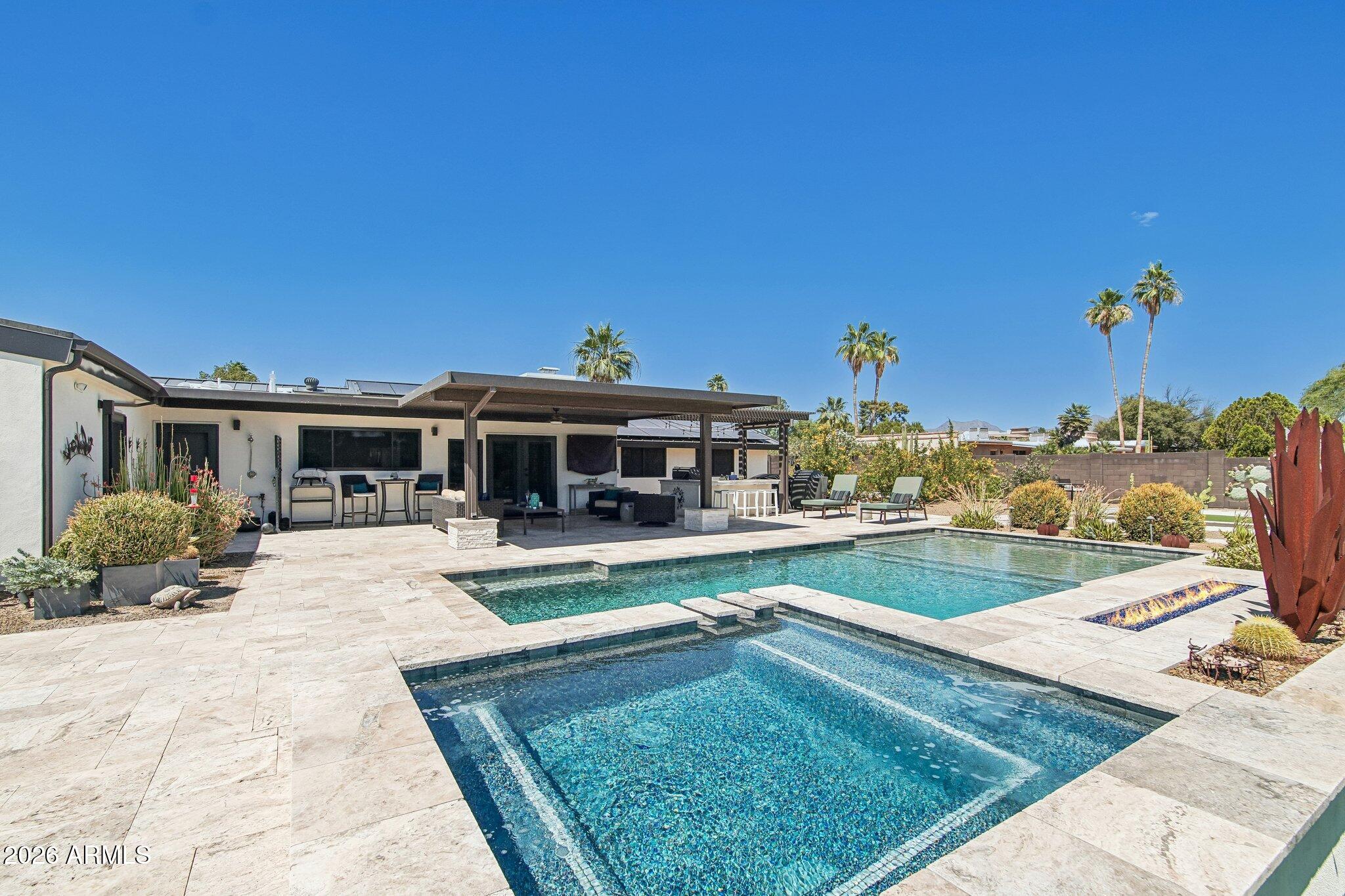 Searching for a 4-bed home in Scottsdale AZ with luxury outdoor living, RV parking, paid solar, and modern design? Welcome to 7001 E Dreyfus Ave, a stunning contemporary cottage style home fully reconstructed in 2018 and thoughtfully designed for comfortable everyday living and effortless entertaining. Situated on a rare half-acre corner lot with no HOA, this 4-bedroom, 3.5-bath residence offers 3,003 sqft of open concept living space in one of Scottsdale's most convenient locations near Kierland, Scottsdale Airpark, Midtown Phoenix, Old Town Scottsdale, freeway access, and nearby desert trails and mountain recreation. Inside, the split 2+2 floor plan plus den/office creates ideal separation and flexibility for families, guests, or remote work. The beautifully finished chef's kitchen features premium appliances, abundant prep space, and a large walk-in pantry designed for family gatherings and social cooking. Naturally lit spacious bedrooms provide comfort and privacy, while upgraded interior touches include a custom wet bar, remodeled fireplace, security screens, garage storage, laundry cabinetry, and designer shower doors.

The backyard was completely remodeled in 2020 and delivers a true resort-style experience. Enjoy a new saltwater pool and spa with travertine surround, covered patio with built-in BBQ, fridge, and bar area, fire pit, putting green, bocce ball court, misting systems, outdoor lighting, turf areas, and a large storage shed. The oversized 3-car garage and separate RV gate will provide exceptional flexibility for motor coaches, boats, and recreational vehicles. Additional exterior investments include owned APS solar, expanded driveway and RV concrete work, block wall extensions, irrigation, and professional landscaping.

Located within the Paradise Valley Unified School District with Sandpiper Elementary and Horizon High School nearby.