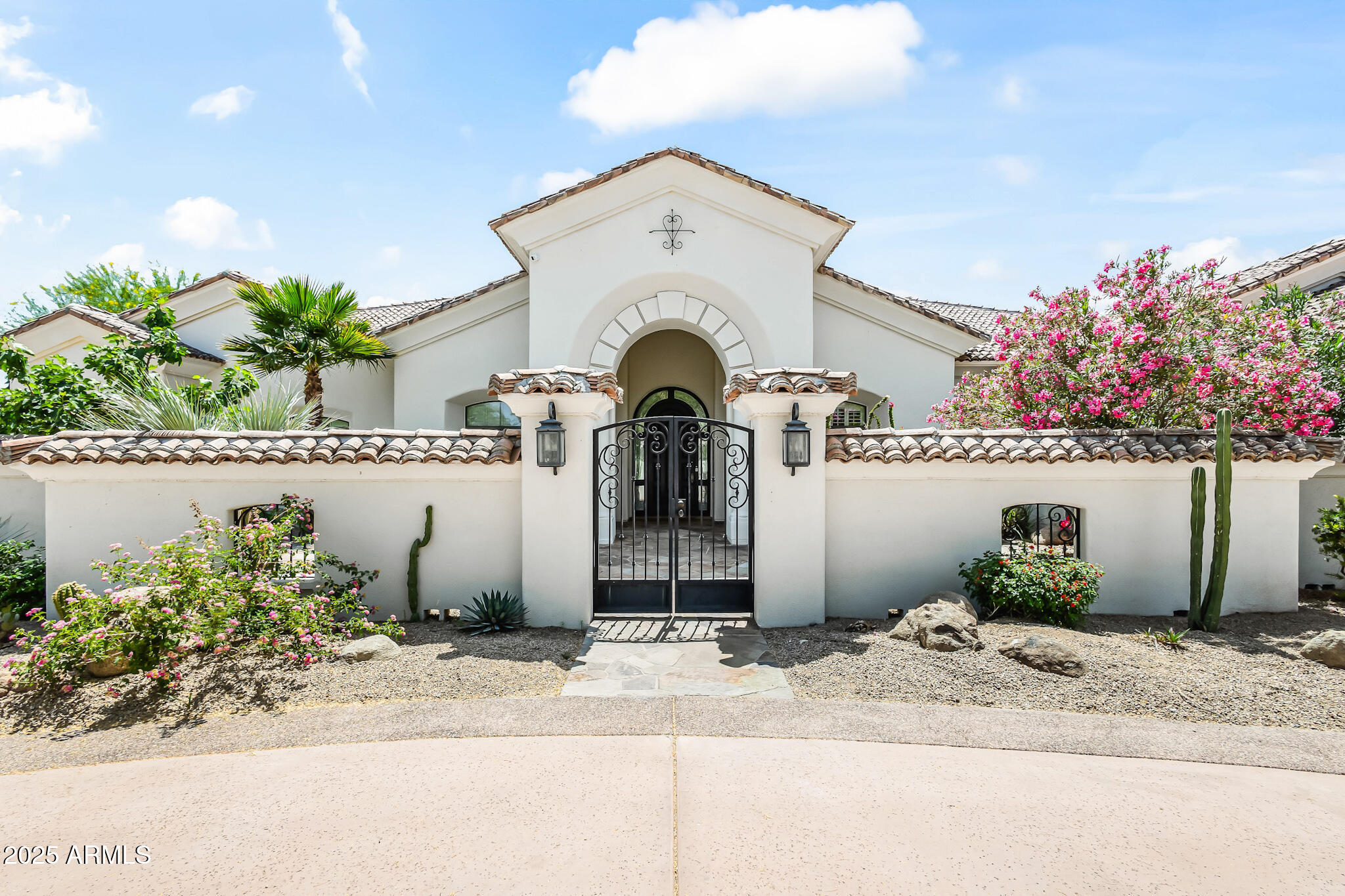 Stunning remodeled estate in one of Paradise Valley's most coveted neighborhoods. Set on over an acre, this 4-bed, 4.5-bath home offers timeless design, lush landscaping, and seamless indoor-outdoor living. Enter through a private courtyard into a light-filled interior with soaring ceilings, arched doorways, and an open floor plan. The chef's kitchen features high-end appliances, double ovens, center island, breakfast bar, and a sunny nook. The spacious great room, formal dining, and gas fireplace make it perfect for entertaining. The luxurious primary suite includes backyard access, fireplace, dual vanities and closets, soaking tub, and oversized shower. French doors lead to a resort-style backyard with a covered patio, built-in BBQ, pool, spa, multiple lounge areas, and firepits. Home includes 4 ensuite bathrooms, office with built-in bookshelves and cabinets, and 3 car garage. Located only minutes away from Arizona's world class resorts, golf, dining, and shopping.