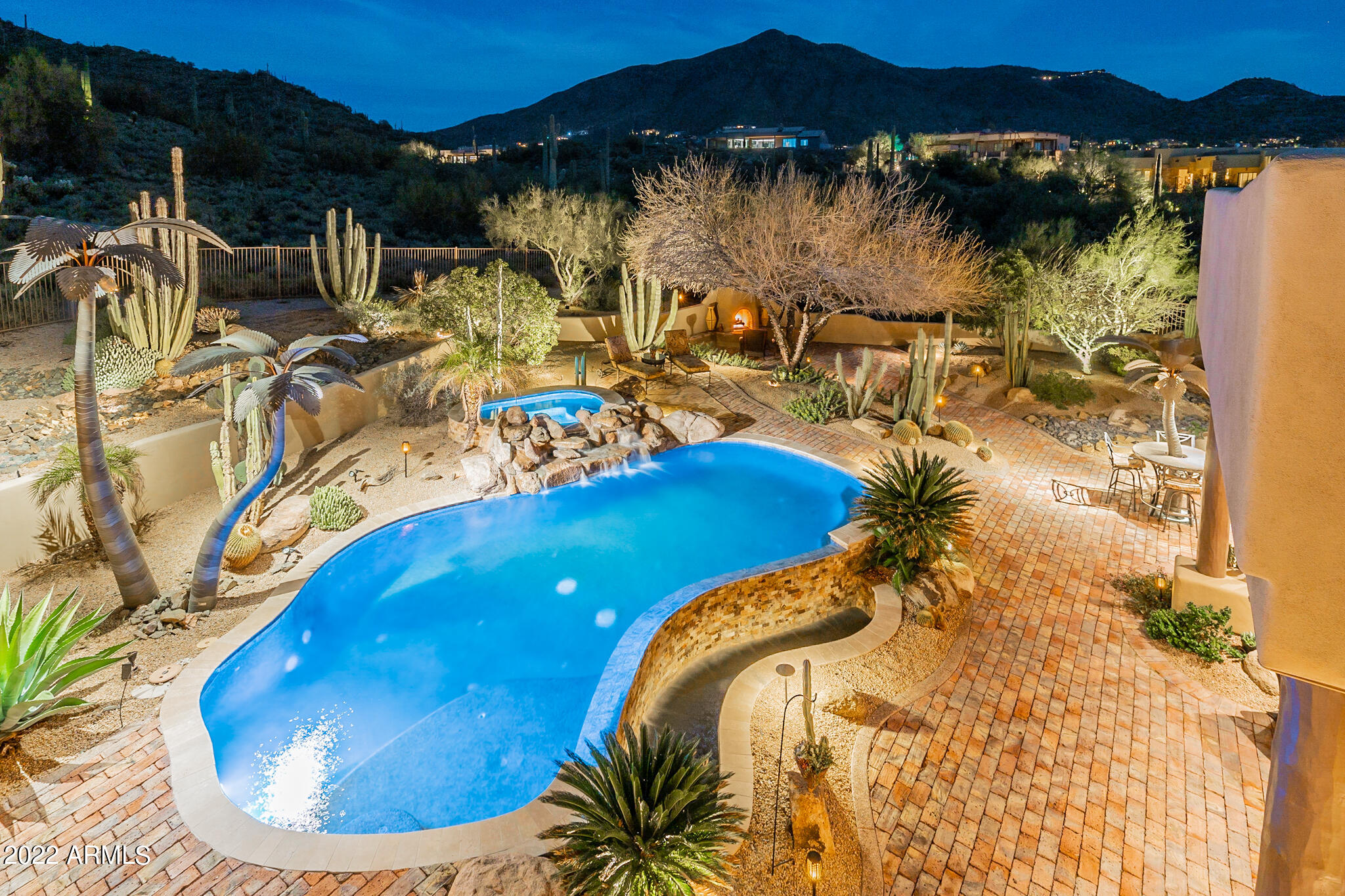 One-of-a-kind Old World inspired Spanish home complete with custom and designer furniture and furnishings. Supreme luxury, architectural appointments and state-of-the-art technology grace the 4184 sq ft main home and 517 sq ft guest house. This stunning property is tucked beside the mountain preserve on a premium 1.92 acre cul-de-sac lot in Canyon Ridge Estates.  The pavered circular drive leads to a private courtyard featuring mature desert landscaping, a view of Black Mountain, and a cozy fireplace. Open floor plan living with thoughtful room separation creates the ideal setting for intimate gatherings or grand affairs. Wood beam Vigas with accent lighting throughout living, dining, family rooms and primary bedroom. Kitchen boasts custom Alder cabinets, accent lights, Rain Forest granite counters, Viking and newer Sub Zero and Fisher & Paykel appliances with center island, cafe dining and breakfast bar. Custom tile barrel ceiling leads you to the impressive owner's suite with a sitting area and fireplace. Three guest ensuite bedrooms, fourth bedroom in the detached casita with a fireplace, kitchenette and sitting and dining areas, custom tiled bathroom and walk-in closet. The resort style-backyard compliments the saguaro-dotted mountain immediately behind. It features multiple seating areas, heated negative edge pool and spa, two fireplaces, built-in BBQ and pool bath. A spiral staircase invites you to the rooftop viewing deck capturing twinkling lights, the splendor of the crimson Arizona sunsets and rugged mountain beauty. Four car extended garage with AC, epoxy floors, ample storage and filtered water wash station. Control 4 Smart Home and Lutron Homeworks lighting system, touch screen sound, reverse osmosis, carbon filtration and salt softeners, and security system.