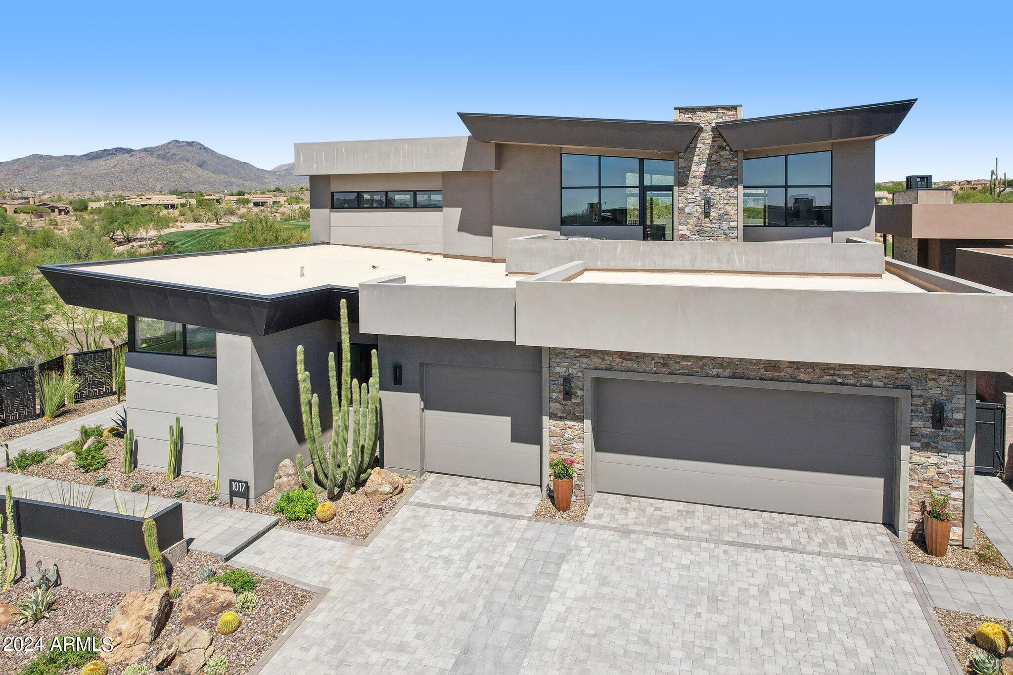 Spectacular, golf course fronting, 6,297 square-foot, two-year-old, Contemporary-styled ultra-high-end, great room plan home with excellent golf and nearby mountain views, offered in prestigious Desert Mountain, in north Scottsdale, AZ.  Desert Mountain is a mature, guard-gated, thirty-eight-year-old golf and outdoor recreation-oriented development set in the foothills of the Continental Mountains north of Phoenix with the private Desert Mountain Club a central attraction.  Membership to the Club is by application, and the seller's sought after full privilege Golf Membership is available to the home's purchaser via a separate transaction with the Club, avoiding a long waitlist (see below for important details).

This home, in the newest Desert Mountain village known as ''Seven'', is within easy walking distance of one of the Club's eight clubhouses, and the first tee of one of its seven golf courses.  This one is an eighteen-hole, par-54 course (rated for handicap purposes) that is easy to walk.  The dining venue at the Seven Clubhouse is an indoor/outdoor affair with a very casual atmosphere.  Sort of a "sports bar" atmosphere and lively all the time, especially since it has a couple of excellent bocce courts, a very well-supported activity in Desert Mountain.    

The home was built by very highly regarded regional builder, Cullum Homes, known for durability and high-quality workmanship, appliances, systems, materials and finishes, not to mention forward-thinking design. These original owners selected what may be the premier site in Seven, with a larger yard, only one neighbor, and most importantly, protected, wonderful permanent, northerly views of the Continental Mountains, just four miles away, across the thirteenth hole of the Club's Renegade Golf Course.  Cart path traffic is hard to hear at a distance of about eighty yards, and being on the thirteenth hole means golfers will be well past the home at twilight, helping ensure a very peaceful environment at that time of day. 

The home features four bedrooms, an office, a three-car garage with storage, and exceptional outdoor relaxation and entertainment areas.  No expense was spared as the owners, long-time Desert Mountain owners and Club members, completed their dream home with over $1.2 million spent on upgrades, which you'll note from the jaw-dropping countertop stone selections, textured backsplashes, to hand selected custom fixtures and lighting. The home is particularly well-suited to the display of art, hanging or otherwise.

The floor plan was customized to maximize the views and the setting.  Walls of glass line the great room, bringing the outdoors inside and providing a picturesque scene from the kitchen, living, and dining areas.  With a northerly exposure, you never have to worry about having to control harsh direct sunlight, and the amount of light coming into the home means a good balance between interior and outdoor light levels.  The upstairs was expanded and converted to a spacious lounge with a full rooftop view deck.  More on these later as we take the tour.

Now let's take the guided tour!  Approaching the home, follow the entryway path beyond the pristine, low-maintenance desert landscaping.  Step through the secured courtyard gate, and the stunning mountain views will immediately take stage. Inside, the home begins with the great room, where tall, gently sloping ceilings create a grand yet comfortable space.  The gas fireplace surrounded by natural stacked stone provides a gorgeous accent wall, and the wet bar with icemaker and lighted 200+ wine cellar make this the perfect setting for a dinner party.

The open kitchen features eye-catching quartzite countertops topping neutral shaker cabinets custom built by Distinctive Cabinetry.  A complete gourmet appliance package includes two Wolf ovens, combo microwave/convection oven, gas range, dishwasher, and Miele coffee maker, along with 72" refrigerator plus two additional refrigerator drawers in the island.  There is plenty of storage in the abundant cabinet space, along with the 108sf pantry.

The dining room has two full walls of windows; imagine the ambiance of al fresco dining in the comfort of your own home!

The spaciousness of the great room continues in the primary bedroom, with full-length windows and glass sliding glass door framing the golf course and mountain views, clerestory windows for natural light, and a floor-to-ceiling fireplace.  The primary bathroom exudes both luxury and tranquility, with "His 'N Hers" floating vanities, topped by the same beautiful quartzite countertops found in the kitchen, which you'll also find as the bench in the walk-in shower.  The massive walk-in closet is intelligently laid out, providing the option for His 'N Her sections, but without a definite division, allowing for flexibility.  Here you'll also find a secret passthrough to the laundry room, which is extremely convenient!

Even the laundry room is upgraded, with a full wall of cabinets, extra refrigerator, sink area with tile backsplash, and access to the side yard with enclosed fencing for your pets.

The main level features two large guest suites tucked away, providing privacy for your guests.  Each suite contains an attractively upgraded ensuite bathroom and a walk-in closet.  There is also an impressively styled half bathroom for dinner guests.

Use either the elevator or the wide staircase to head upstairs.  At the top of which, you'll find a space completely reimagined during construction to provide an unforgettable entertaining experience.  Big-screen television, plenty of room for guests to sit or mingle.  A full bar, where underlit onyx countertops will attract your attention.  Icemaker, wine fridge, and two refrigerator drawers.  Architecturally interesting ceilings give this space a fun twist, and double-sliding doors capture those soothing mountain views, while providing access to the rooftop deck overlooking the golf course.  Completing the upstairs space, don't miss the office with extensive built-ins, an additional half bathroom, and another guest suite with full ensuite bathroom and walk-in closet.

And last but certainly not least, the backyard!  Step through the living room's full-wall sliding glass doors to the spacious patio. Here you'll find more than enough space for both seating and dining areas, topped by a ceiling fan and two built-in heaters, making this a comfortable retreat any time of year.  Just outside the patio is the built-in BBQ with large countertop prep space, plus storage and lighting.  Take a dip in the infinity edge pool, relax in the hot tub, or pull up a chaise lounge on the pool's large Baja step to take in some sun.  As evening approaches, have a seat by the firepit and watch the magic as sunset turns the mountains from purple to fiery pink, followed by the starry night sky.  This idyllic scene can be yours to enjoy every day!

More on the Club membership... The "separate transaction" mentioned above involves paying the Club an initiation fee (currently $200,000 for the full Golf Membership).  Please note that some level of club membership is required for all homeowners in Seven.  Call the Club for details.  All memberships include access to all the Clubhouses, including: the Sonoran Clubhouse (featuring premier quality swimming, tennis, fitness (equipment, classes, personal trainers, yoga, etc., pickleball, bocce, spa, and croquet), and all ten dining venues.  Golf Members alone have full access to all seven courses and four practice ranges.  Property owners have access to the amazing "Bark Park" (essentially a country club for dogs) and the over twenty miles of wonderful hiking/biking trails in the mountains at the back of the property.  Considerable recent and ongoing investment is keeping Club facilities state-of-the-art, funded out of general funds, not through assessments.

How close is it to what you want and need? Five minutes to excellent shopping and nightlife in Carefree and Cave Creek.  Thirty minutes to Scottsdale Airpark, or less than an hour to Phoenix Sky Harbor Airport. Two hours to Flagstaff (snow skiing), or continue north to the Grand Canyon or Lake Powell. Four and half hours to Las Vegas, six to Newport Beach.

Desert Mountain is an 8,200 acre, gated, master-planned community with about 2,000 homes and about 200 homesites yet to be built upon. It is in a noticeably quiet, serene, safe (manned entry gates; security patrols), secure and beautiful location, spread east to west across the foothills of the Continental Mountains in the High Sonoran Desert on the northern edge of Scottsdale, with homes at elevations ranging from 2,600' to 3,500' ASL. The Tonto National Forest (fourth largest in the country), borders the community to the north. Desert Mountain has enjoyed significant success over the years. Buyers have come from all states and worldwide, but especially from California, Colorado, Oregon, Washington and the Upper Midwest. Most owners are Club Members, and virtually all of them seem to have made socializing and having fun a key priority. Another positive is real estate taxes strikingly lower than many places in the Northeast, Midwest, or West Coast. (2023 taxes on this home were only $7,548). Demand for homes has remained strong.

Desert Mountain's weather is famously dry and sunny. Our risk of natural disasters is extremely low. Being higher and somewhat removed from the city means the stars are bright at night, the air typically much cleaner, and the daytime high temperatures can be about ten degrees cooler than the Valley floor, every day of the year. Summers are very enjoyable since it only gets over 100 degrees only about ten or twelve days a year here, compared to ninety days at Phoenix Sky Harbor Airport, with low humidity. At night in the summer, the temperatures drop fifteen to twenty degrees, a significant difference from life on the Valley floor. You would be amazed how comfortable 95 degrees is at night or in the shade. So, being in Desert Mountain on a year 'round basis is an attractive proposition.

In addition to the foregoing, the owner of this home will be close to major league and collegiate sports, fabulous medical care (including the Mayo Clinic and hospital), terrific air service, and a wide variety of cultural attractions.

"Paradise" does not overstate what Desert Mountain is for the people who get to live here.  Thanks for your time. If this home and Desert Mountain sound like a possible fit for you, come take a look!