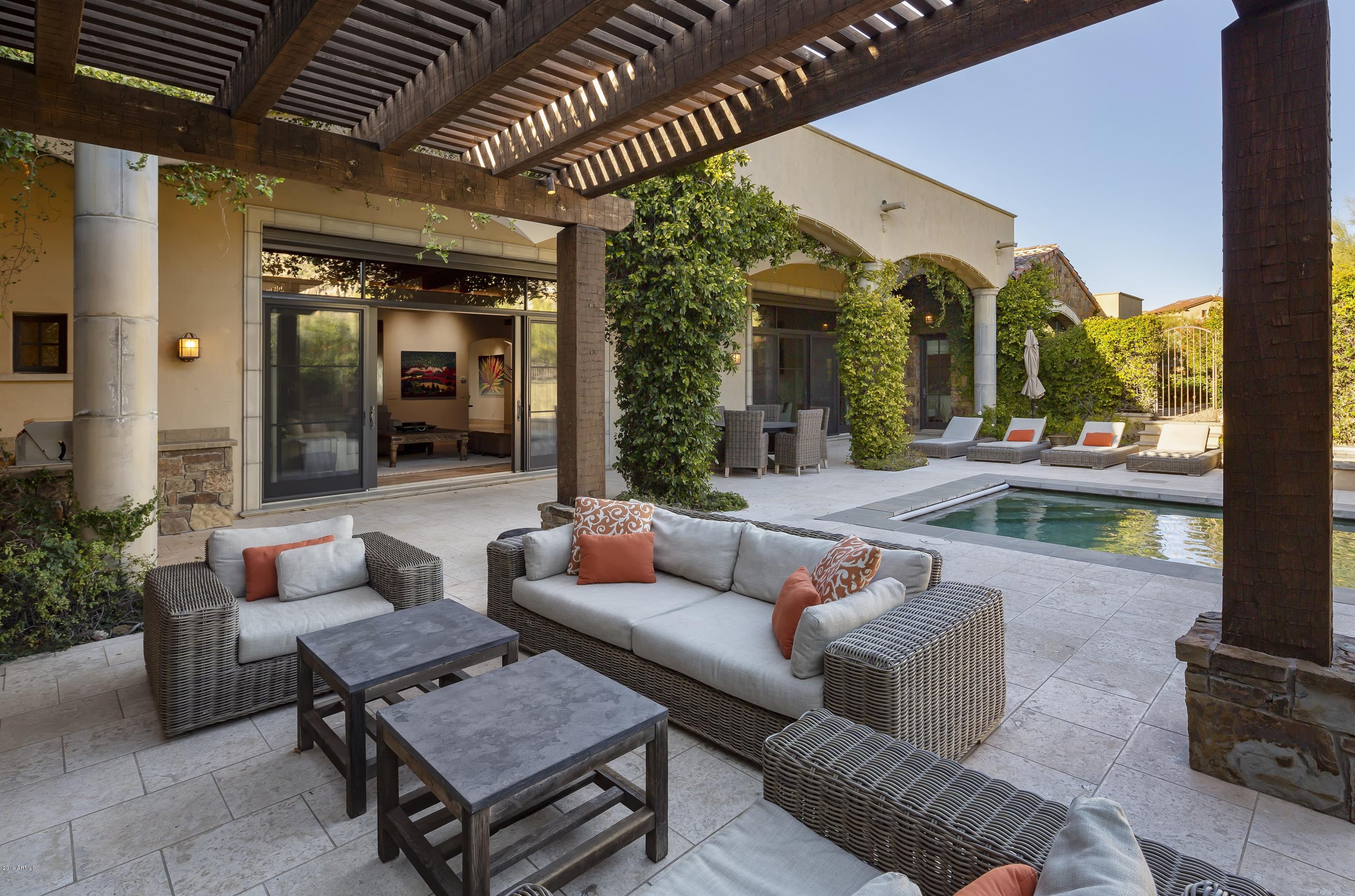 Pinnacle Peak views with warm, transitional interiors in the award-winning community of Estancia * Authentic use of stone, hand-hewn woods and glass with an Old World architectural-style * Kitchen opens to family room and all rooms open to private patios or courtyards * Interior details include venetian plaster walls, travertine and hardwood flooring, stacked-stone and masonry fireplaces, wood beamed and tongue & groove ceilings * Kitchen includes alderwood cabinetry, granite slab counters and Dacor, SubZero and Asko appliances * Master suite with steam shower, his/her closets and exercise studio * Guest house with sitting area, kitchenette and dual-vanity bathroom * South-facing outdoor entertaining includes mature landscaping, heated pool with motorized cover, heated spa and built-in BBQ station * A 3-car garage completes the residence *