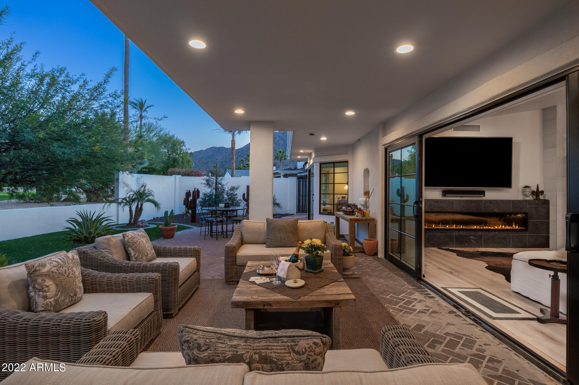Secluded within the exclusive neighborhood of Mountain Shadows East, this home exudes warmth combined with casual elegance, and has been thoughtfully upgraded for today's aesthetic tastes.  Bold, yet simple, the subtle earth tones promote relaxation and renewed energy.  An open concept plan joins the gourmet kitchen to the living/dining areas that feature an LED fireplace.  Enjoy the clean lines, vaulted ceilings and commanding views.  The chef's kitchen with marble and satin granite surfaces and high- end appliances makes a perfect home for both intimate and large gatherings.   The primary bedroom invites the outdoors in and provides access to your private backyard oasis.  The spa - like primary bath includes a soaking tub, gorgeous walk - in shower and custom closet. Guest quarters are placed at the opposite end of the home.  This design allows perfect separation of guests from the homeowners retreat.  The exterior features a luxurious front courtyard and a magnificent backyard with gas BBQ area that offers direct access to the kitchen and a soothing fountain.  Elegant living spaces are designed to compliment our desert climate while maximizing mountain views.  Comfort, quality, and sophistication are achieved throughout the many distinctive details. A Three car garage completes the perfect home.