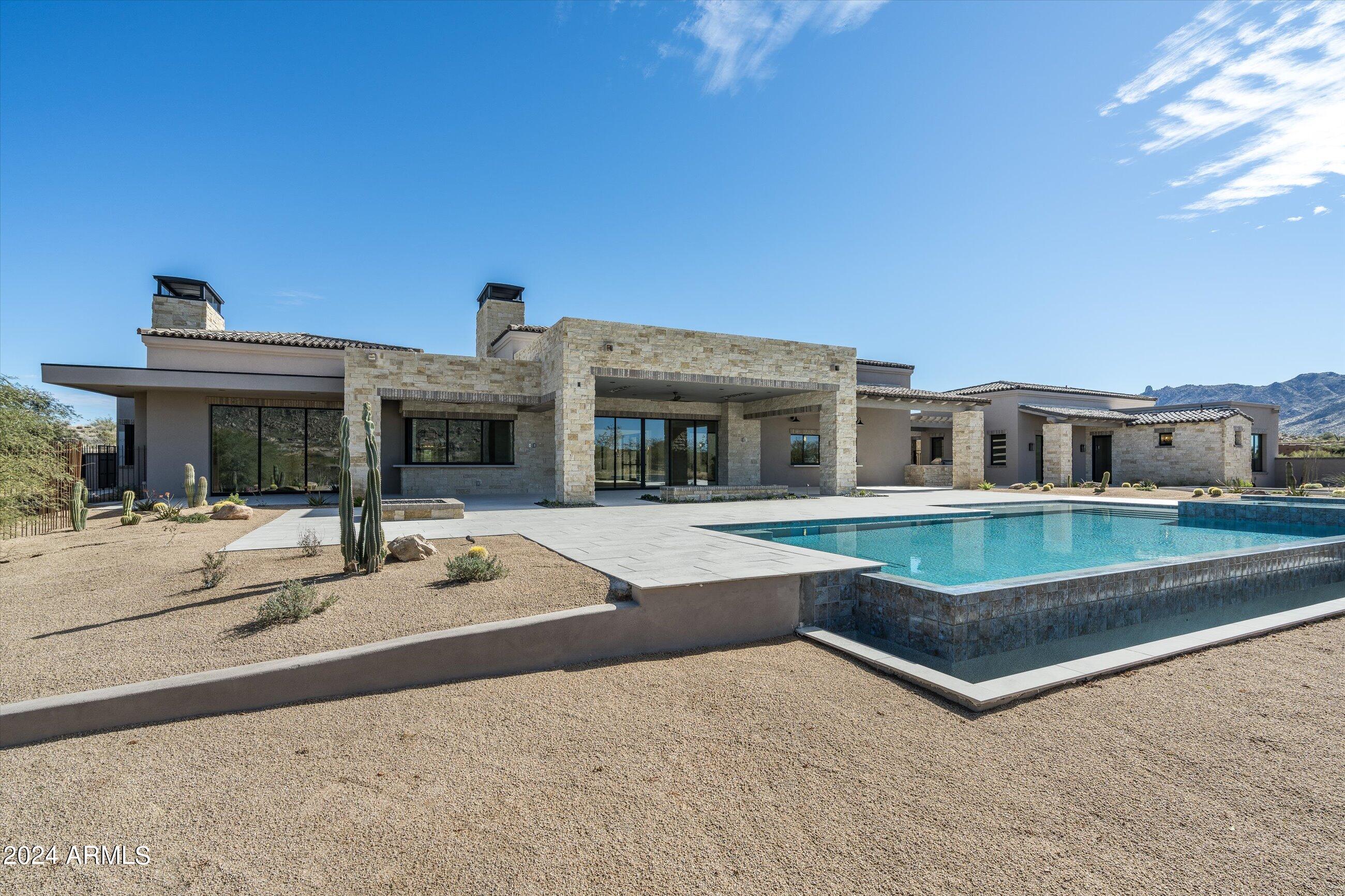 Recently Completed, this spectacular Lineage built spec home is in the exclusive 11 lot gated community of Troon Canyon Estates. It is situated on  3.47 acres with breathtaking views of Troon, Mazatzal and McDowell Mountains. This stunning home features the Lineage open floorplan showcasing retractable walls and windows of glass that open to expansive patios for the finest in indoor/outdoor Arizona living. This 6,717 square foot estate home features 7 large garage bays. All 7 bays have the option of car lifts making it up to a 12 car garage. The kitchen features Wolf/sub-Zero appliances, 2 dishwashers, a built-in Coffee bar and oversized island. The great room has an indoor/outdoor cantina bar and custom fireplace. The master bedroom includes a kitchenette, fireplace, and retractable doors to the patio. The master bath includes 2 water closets and the large customized closet has washer/dryer. Backyard has oversized pool, Bocce Court, outdoor kitchen and two outdoor showers. Large 2 room casita has a kitchenette, full bath and stunning view. There are 3 more lovely guest suites with courtyard access and retractable glass openings.