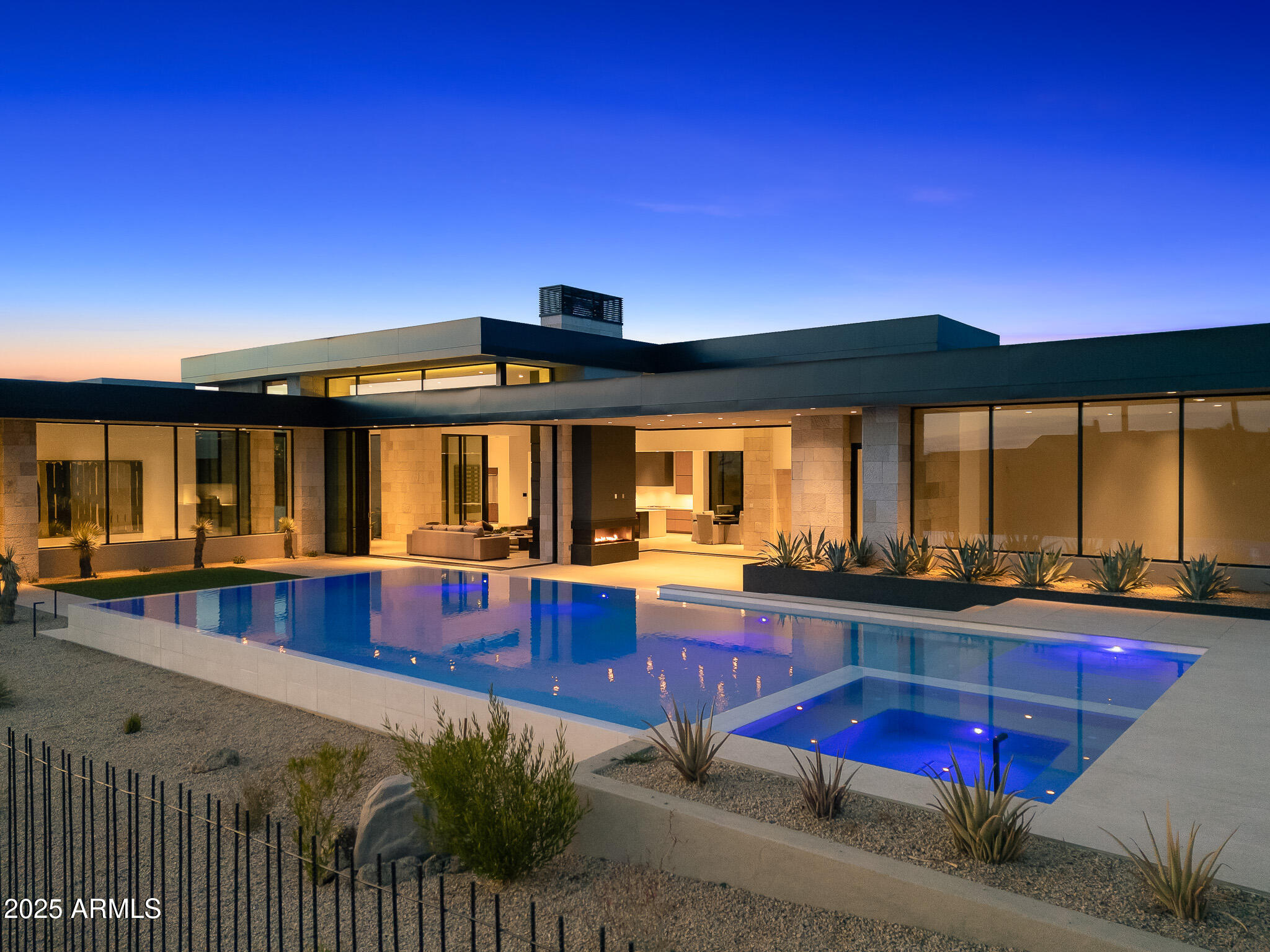 Designed by Award-winning architect C.P. Drewett this seamlessly crafted modern home in north Scottsdale's Estancia Golf Community is jaw dropping. With a nod toward Mid-Century Modernism—characterized by its boxy architecture, straight lines and minimalist nature—the home's design takes full advantage of its stunning setting. Pocketing doors slide open to allow indoor/outdoor living, creating a pavilion-like ambience where the spaces meld into one another. A palette of materials includes hemlock, bronze, and textured limestone inside and out. The organic work of modern architecture is a perfect example of how a well-executed design can so effortlessly respond to the true essence of its site. The modern kitchen is beautifully designed complete with Wolf convection steam oven, speed oven, induction cooktop, gas cooktop, coffee system and a hidden pantry with appliance garage, wall oven and ice machine. Continue through the home to find a split primary suite, two guest suites, an office in the main house, and a detached guest casita with a bedroom suite and sitting area. A 1,322-square-foot luxury car lounge provides the perfect setting to showcase your auto collection while entertaining.

Estancia is a luxury residential community centered around golf and located at the base of Pinnacle Peak in north Scottsdale, Arizona. The community offers a private, members-only golf club with an 18-hole championship course designed by Tom Fazio. The clubhouse amenities include dining, a fitness center, tennis, pickleball and basketball courts, and a swimming pool. Residents enjoy views of Scottsdale's landmark Pinnacle Peak and a serene desert setting just minutes from world-class dining, shopping and entertainment.