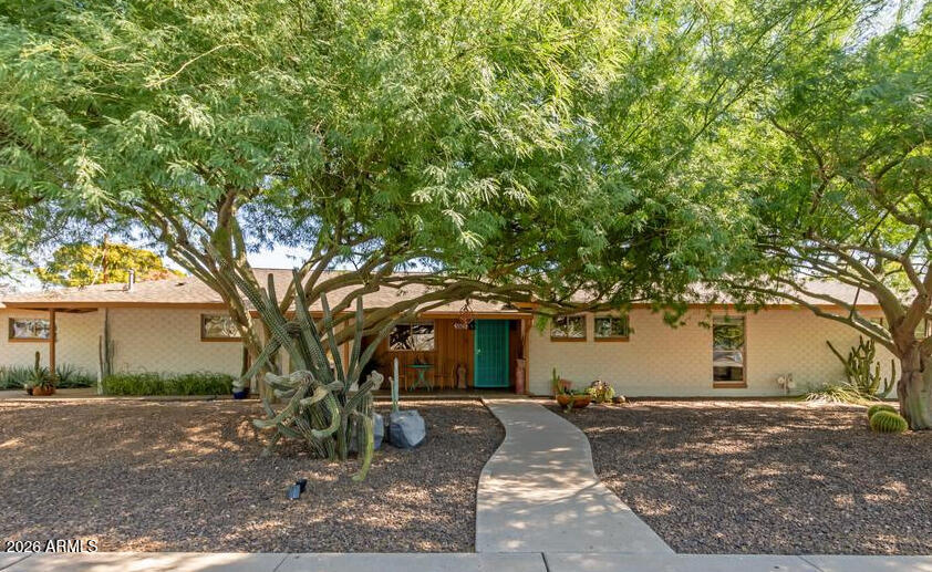 Historic 1954 Del Webb ranch-style home in the heart of Phoenix on a premium 1/3-acre corner lot with mature shade trees. This 2,350 sq. ft. home features owned solar with backup battery, RV gate, 2-car side-entry garage, 3-car covered parking, wood flooring, neutral finishes, and a living area with a fireplace. The galley kitchen offers solid-surface counters, mosaic tile backsplash, built-in appliances, recessed lighting, and ample cabinetry. The primary suite includes a sitting area, outdoor access, and an ensuite bath, while guest quarters offer a separate entry and private bath. Enjoy a covered patio, extended paver seating area, and hot tub in the spacious backyard. See the Documents tab for the history of this unique property.