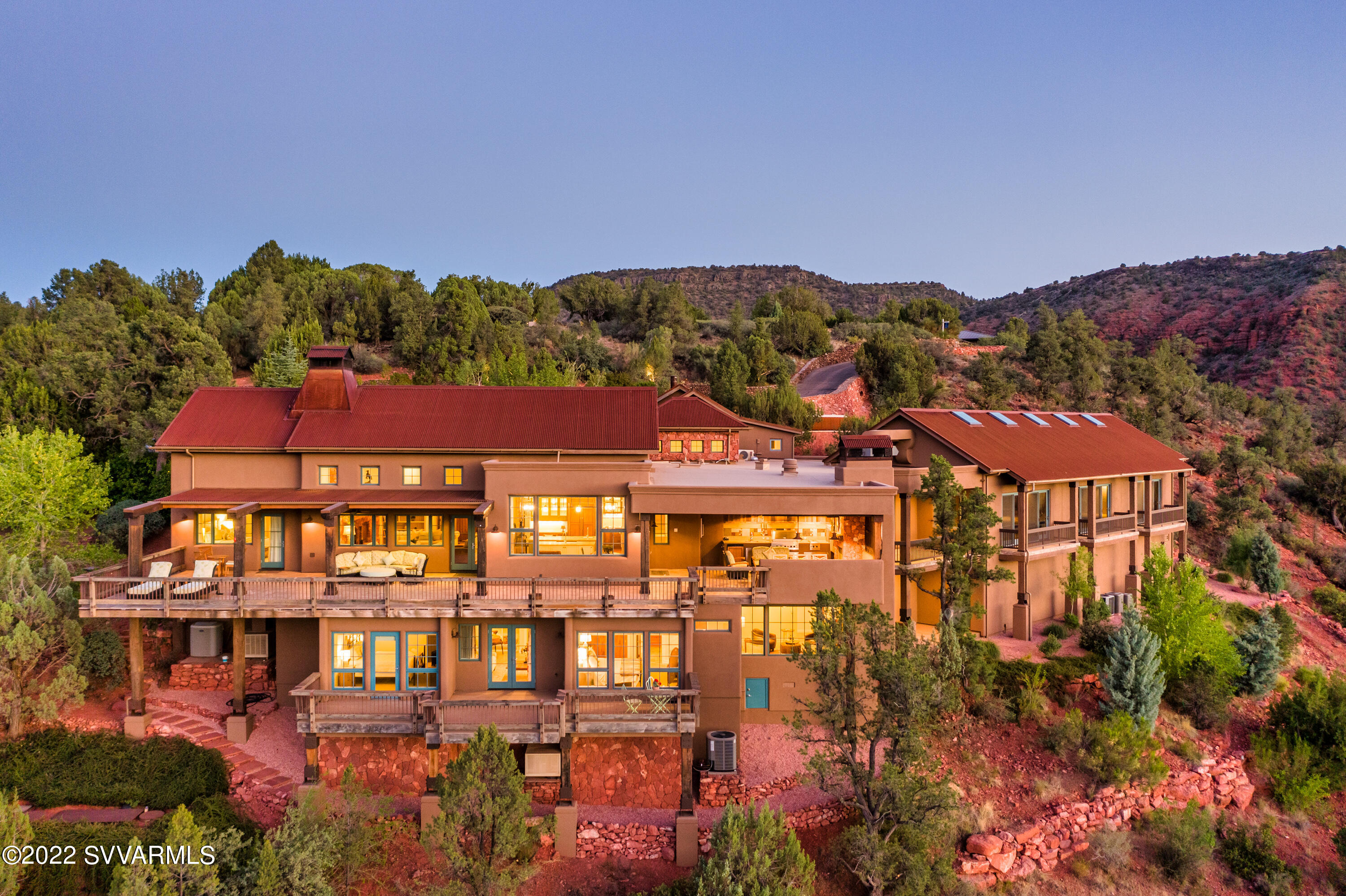 Exquisite estate home provides over 5-acres of privately owned land against national forest, located in an exclusive gated community near West Sedona. Imagine your own resort-style living with all the luxurious amenities included:  indoor pool; fitness room; steam room; dry sauna; temperature-controlled cellar for 1200 bottles of wine/bourbon; 700 SqFt indoor shooting range; state-of-the-art outdoor kitchen with built-in BBQ and Viking smoker, and outdoor fireplace; decks for all living areas; elevator to guest quarters with 2 guest bedroom en-suites, den, plus bonus rooms for intimate gatherings or guest sleeping areas. Most furniture available for purchase. No short-term rentals allowed. Additional amenities & upgrades included in MLS attached documents - also available upon request. SHARED WELL: 25,000 Gallon Well Going To Be Installed With 4 Pumps & Generator. Services 9 Properties. HOA Dues Include Well Costs As A Shared Owner. 

2 PARCELS INCLUDED IN PRICE: 408-32-068K (3.28-acres residence) + 408-32-068M (1.82-acres backs to forest). 

INTERIOR AMENITIES ON MAIN LEVEL:
- Elevator To Lower Level
- Kitchen: Eat In Kitchen With Bar, Breakfast Dining Area & Lounging Area, Huge Pantry, Viking Professional Gas Range, Viking Oven, Bar/Wet Bar, Granite Kitchen Island,  Vaulted Ceilings
- Formal Dining Room
- Outdoor Kitchen: Covered Patio With Built-In BBQ, Viking Smoker, Fireplace, Lounging Area + Built-In Seating, Dining Area, Outdoor Heater & Ceiling Fan, Incredible Views
- Great Room: Floor-To-Ceiling Red Rock Fireplace (Gas), Vaulted Ceilings, Wooden Beams, Wood Floors
- Master Bedroom/Bathroom: Built-in Gas Fireplace, Beautiful Draperies, Built-In Cabinetry For Media Equipment, Wood Floors, Bathroom With Private Double Vanities, Water Closet (Toilet), Walk-In Shower, Tub, 2 Walk-In Closets, Ample Bathroom Storage
- Laundry Room: Washer & Dryer Included & Built-In Secretary Desk
- Commercial-Grade Steam Room
- Commercial-Grade Dry Sauna
- Indoor Lap Pool (Equipment Is Not Installed - Owners Were Going To Build Guest Casita In This Area. Quote For New Saltwater Pool Equipment Just Under $15,000)
- Fitness Room
- Storage Room Off Garage
- 2 Car Garage With Room For 3 Cars & Ample Parking For A Large Gathering

LOWER LEVEL
- 2 Guest Bedrooms With En-Suite Bathrooms And Viewing Decks
- 1200 Bottle Wine Cellar (Temperature & Humidity Controlled)
- Bourbon Room (Bonus Room) With Fireplace (Bonus Room For Closet or Bathroom)
- Bar/Kitchenette Area For Guests 
- Den (TV Room For Guests) 
- Storage Room & Closet With Access To Mechanicals
- Indoor Shooting Gun Range With Steel Walls & Approximately 700 SqFt ($250,000 Cost To Build). 

UPPER LEVEL
- Room Above Garage With An Abundance Of Possibilities (Game Room, Art Studio, Craft Room, Office, Etc)

EXTERIOR FEATURES
- Expanded Parking & Road To Meet Parking Needs For Large Gatherings
- Water Feature At Front Courtyard
- Aerobic System Serviced Monthly By AZ Wastewater
- Low Maintenance Landscaping On Drip System
- 1,000 Gallon Propane Tank Serviced By John Graves Propane
- Viewing Decks Off Nearly Every Room

RECENT UPGRADES
- Treated & Painted All Exterior Beams & Wood 
- New Exterior Paint
- New Landscaping & Steps
- New AC
- New Dishwasher
- New Roof

BONUS 
- Pool Is Solid Concrete
- Fire Sprinklers In Crawl Space (Important For Insurance)
- Electric Is About $400/Mo (Well-Insulated Home)
- Swamp Coolers In Working Condition
- Gas Hot Water Heater
- Roof Is Prepped For Solar (Not Included With Home)
- Home Is Prepped To Add A 1200 AMP (Not Included With Home)
- Ample Roof To Build A Private Guest Casita Or ATV Storage
- Furnishings Available To Purchase. 
- All 16 lots are owned by the 5 current owners.