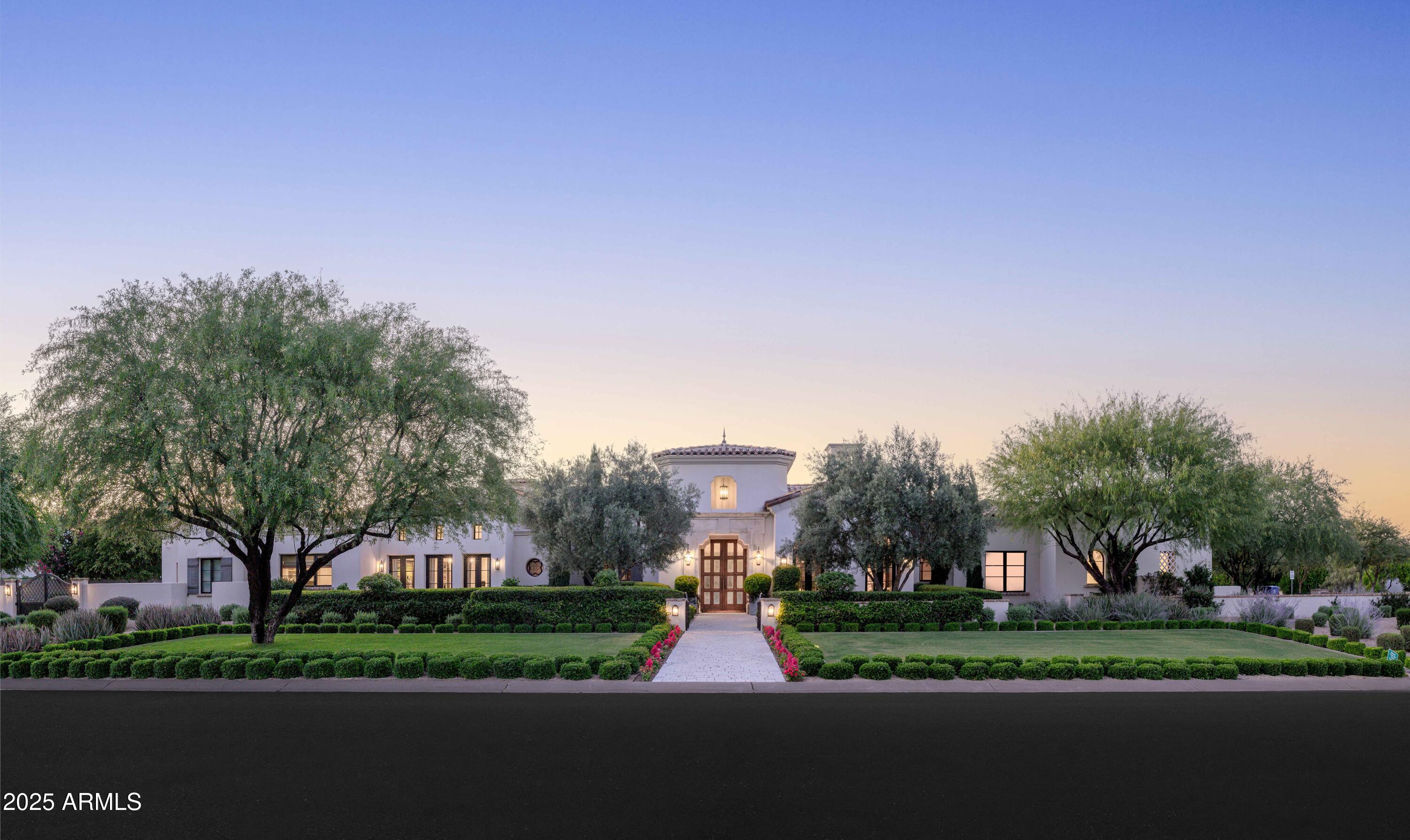 Welcoming Paradise Valley's timeless and elegant privately gated property situated on 1.1 acres of lush, mature landscaping with unobstructed mountain views in the heart of Equestrian Trails. This stunning 9,347 square foot Santa Barbara style home exudes charm, character, and meticulous craftsmanship throughout. Designed by renowned architect Matthew Thomas, built by Mike Foster Custom Homes, distinctive garden design executed by Berghoff Design Group, and lighting package by Walter Spitz, Creative Designs in Lighting - this home is sure to impress, offering unparalleled living in one of Paradise Valley's most desirable areas. Step through the grand entryway where every architectural detail was carefully crafted, overlooking the salt water pool and well manicured and maintained grounds. The soaring ceilings, handcrafted details, and expansive living spaces create an inviting yet opulent atmosphere. The thoughtfully designed floor plan features 6 spacious bedrooms, each a private retreat, and 7.5 beautifully appointed bathrooms. 

Making your way to the heart of the home, you are greeted with unobstructed Mummy Mountain views from the formal dining room and front patio - perfect for entertaining. The kitchen is overlooking the lush courtyard, complete with top-tier appliances, custom Desert Cove cabinetry, matte Carrera marble counters, and a large solid walnut island in the center that flows effortlessly into the open-concept great room to the north, perfect for entertaining. A beautiful custom chandelier hangs from the cupola above the island, bringing natural light and reflection into the space. Off the great room, you experience true indoor-outdoor living, including accordion doors opening up to a serene courtyard, covered patio, private garden and meticulously landscaped grounds that evoke the charm of a Mediterranean villa.

Past the great room, the west wing includes a luxurious primary suite with a spa-inspired ensuite, a dedicated home gym, and two private courtyards. 

In the east wing, the home features three more en suite bedrooms, a playroom with cupola and tongue and groove ceiling with statement chandelier, and custom leather doors leading into a state-of-the-art theater room with ample storage throughout. 

One of the most exciting and unique aspects of this property is the attached guest house or party barn: an architectural masterpiece including 100+ year old reclaimed wood from a farm in Idaho. This incredible structure brings history, charm, warmth and a uniqueness to the property. The barn features a full size kitchen, ice maker, wine fridge, reverse osmosis system, loft bedroom with a full bath, two half baths downstairs, laundry room with stacked washer and dryer, and a private single-car air conditioned garage which is perfect for caterers prepping food. This barn is the ultimate entertainer's dream, allowing for large gatherings where you can lock the structure off from the rest of the home to maintain privacy.  Outside of the accordion style doors, you will find built-in heaters, an outdoor gas firepit, and market lights above the patio for a true indoor outdoor lifestyle.  A separate side entrance allows your guests to enter this unbelievable structure, without entering your main home ensuring complete privacy.  

Situated in one of Arizona's most prestigious communities, this architectural work of art offers privacy, tranquility, and proximity to world-class dining, shopping, and outdoor recreation. A true testament to design and craftsmanship, this estate is an extraordinary opportunity to own a one-of-a-kind residence that exudes luxury, sophistication and warmth, offering an unparalleled living experience in one of Paradise Valley's most desirable areas.