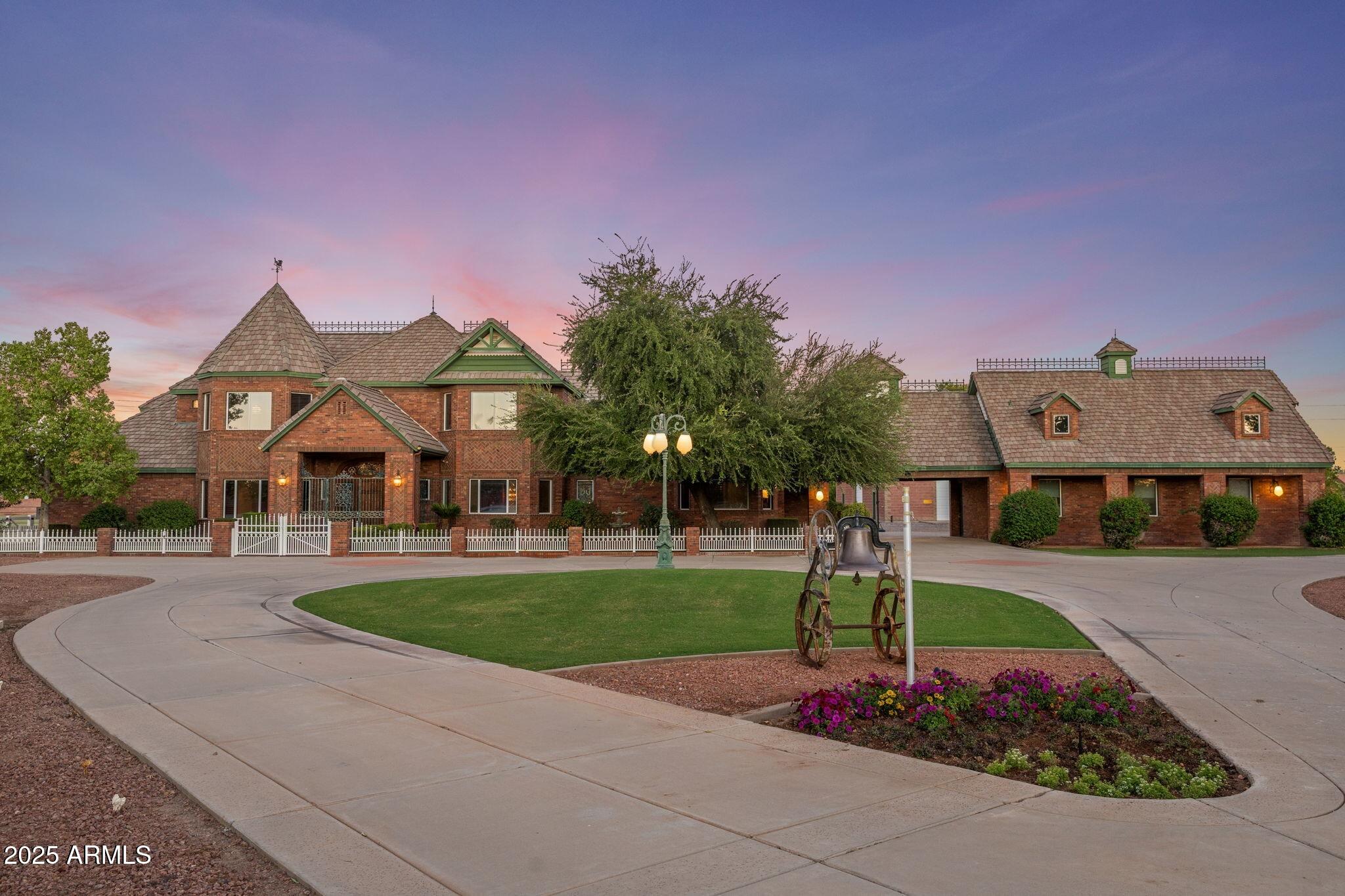 Where timeless elegance meets Arizona heritage — this iconic Victorian-inspired estate rests on 6.175 irrigated acres in the heart of Gilbert, offering an unmatched blend of luxury, privacy, and equestrian living just minutes from vibrant Downtown Gilbert and SanTan Village. Spanning 6,831 sq ft with 5 bedrooms and 7 bathrooms, the home showcases 12' ceilings, a sweeping grand staircase, stained glass details, and handcrafted millwork throughout. The main-level primary suite features dual walk-in closets, while the fully finished basement includes a kitchenette, full bath, and generous storage. Step outside to a resort-style pool, lush irrigated grounds, multiple covered patios, and full equestrian amenities including a 36×64 shop, hay barn, and stalls. With no HOA, a private gated entrance, and room to roam, this Gilbert landmark offers elegance, freedom, and legacy living. If privacy, history, and horses are your love language, welcome home.