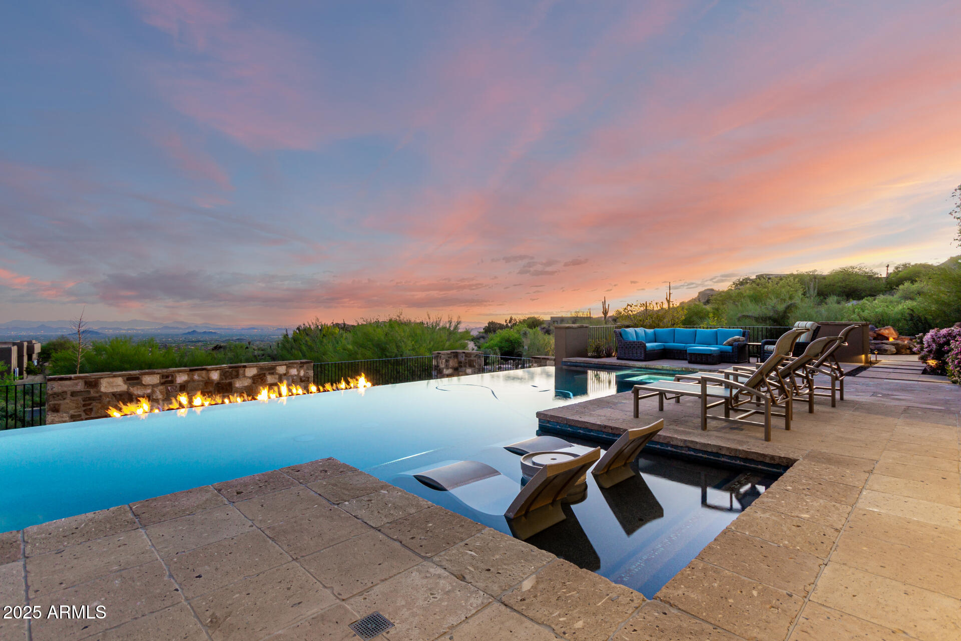 Desert Mountain GOLF MEMBERSHIP available from Seller with Club approval. 
Welcome to Bella Vita, a breathtaking estate nestled within the prestigious Desert Mountain community of North Scottsdale. Inspired by the timeless elegance of an ancient Italian manor house, this remarkable property offers an unparalleled blend of rustic Italian charm and modern-day luxury. Designed by renowned architect Ron Brissette, every corner of this residence tells a story of thoughtful craftsmanship, offering both comfort and sophistication for those seeking the best in desert living. Bella Vita is a sprawling estate that spans over 9,500 square feet, offering five generously sized ensuite bedrooms, each thoughtfully designed for privacy and comfort. As you enter through the grand front doors, you are greeted by the rich textures and finishes that evoke a sense of history, balanced perfectly with contemporary amenities. High ceilings, dramatic beams, and warm stone floors transport you to an era where elegance was the standard, yet every detail has been modernized to meet the demands of today's lifestyle.
The formal living and dining rooms are nothing short of spectacular, offering the perfect space for entertaining or simply enjoying the beauty of the desert surroundings. Picture-perfect windows and French doors allow natural light to flood the interior, while offering views that frame the rugged mountains and desert beyond. Whether hosting intimate dinner parties or large-scale gatherings, these spaces offer both grandeur and intimacy, providing the perfect setting for making memories.
For the culinary enthusiast, the Bella Vita kitchen is a dream come true. This professional-grade kitchen features Meile appliances throughout, including a six-burner gas range, dual ovens, and a Sub-Zero refrigerator. The expansive granite countertops, custom cabinetry, and oversized island are designed for both functionality and style. Whether you're preparing a casual meal for family or a gourmet feast for guests, this kitchen will exceed every expectation.
Adjacent to the kitchen is a stunning, fully equipped outdoor living space. Here, the spirit of Italian hospitality truly comes to life with a professional gourmet BBQ, a classic wood fire pizza oven, and an expansive dining area that invites you to enjoy the beauty of Arizona's stunning sunsets. The outdoor living area is a true extension of the home, perfect for alfresco dining, casual entertaining, or simply unwinding as you take in the view.
Beyond the luxurious interiors, Bella Vita offers a wealth of amenities designed to elevate your lifestyle. A true highlight is the negative-edge pool, which appears to spill into the desert landscape below, offering sweeping views of the surrounding mountains and the lush desert flora. The pool area is complemented by a thoughtfully designed splash pad for the younger members of the family, ensuring everyone can enjoy the outdoors in comfort and style.
For those seeking more active pursuits, the bocce ball court provides an idyllic setting for friendly competition, while the Lookout Balcony Living Room offers a quiet retreat with panoramic vistas. Whether you're enjoying a morning coffee as the sun rises over the desert or savoring a glass of wine in the evening, this unique space invites you to slow down and take in the beauty of your surroundings.
The home also features a grand library, perfect for those who enjoy reading, working, or simply escaping to a quiet sanctuary. Rich wood paneling, custom built-ins, and expansive windows make this room feel both regal and comfortablea place where one can unwind with a good book or conduct business in an inspiring environment.
The home's design expertly integrates both luxury and practicality. The four-car garage offers ample space for vehicle storage and ensures that every element of your lifestyle is seamlessly accommodated. Whether you're an avid collector of fine automobiles or need extra storage for recreational gear, this garage meets all your needs with style.
As with any home of this caliber, Bella Vita offers multiple fireplaces throughout the home, providing warmth and ambiance in every room, from the cozy library to the spacious formal living areas. These fireplaces, combined with the rich textures and materials used throughout the home, create an atmosphere that is both welcoming and timeless.
Bella Vita is more than just a residence; it is a lifestyle. The estate offers a level of privacy and tranquility that is unparalleled, while also being within easy reach of the world-class amenities that Desert Mountain has to offer. Whether you're spending your days on the golf course, hiking the miles of trails, or enjoying the resort-style amenities, this home allows you to experience the best of Scottsdale living.
Designed with meticulous attention to detail by Architect Ron Brissette, Bella Vita is an exquisite home that captures the heart of both old-world elegance and modern luxury. From the moment you step through the front doors, you are enveloped in a sense of placeone that is both grounded in history and yet completely of the present. Every inch of this home has been crafted to provide a sanctuary of peace, beauty, and comfort, while offering an exceptional setting for entertaining and enjoying life's most cherished moments.
Come discover the extraordinary balance between rustic Italian character and contemporary comfort at Bella Vita. This home is not just a place to liveit's a place to experience the good life, to create memories, and to live the lifestyle you've always dreamed of.