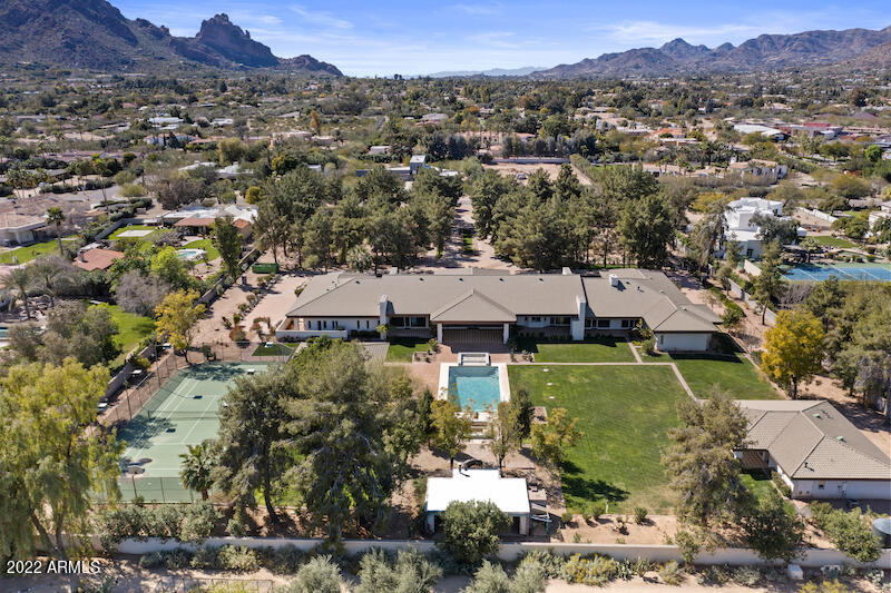 PREMIER PARADISE VALLEY ADDRESS - 4.38 acre privately gated estate w/2 wells servicing the soft contemporary home.  See parcels: APN  174-62-005F (3.38 AC) and APN 174-62-005G (1 AC).  Guest house was remodeled 2021 (1,395 SF); Main house 8,051 SF.  Walls of glass surround the home with natural light and high ceilings.  Access the property through a magnificent circular tree-lined drive with symmetrical gardens and N/S tennis courts/6CG.  Camelback Mountain views.  Bring your design team/remodeler/builder to make this home your custom dream estate.