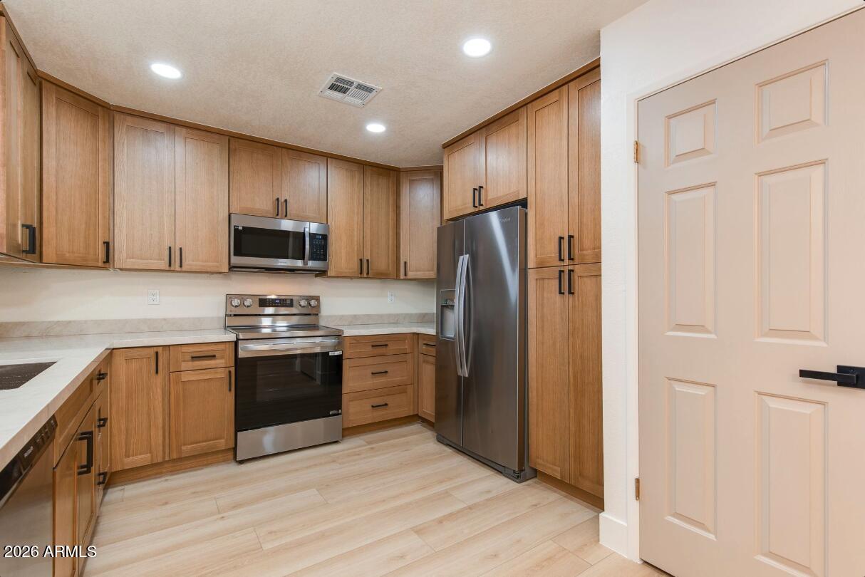 Beautifully remodeled condominium with stunning views of a resort-style clubhouse and pool. Thoughtfully redesigned with today's most desirable finishes, this move-in-ready home features luxurious Taj Mahal quartz countertops, custom white oak cabinetry, wide-plank LVP flooring, fresh interior paint, updated baseboards, designer lighting, modern fixtures, and stylish hardware throughout.

The building is equipped with an elevator for easy access, while one of the community's five pools is just steps from your door. The main clubhouse, fitness center, and resort-style amenities are only a short walk away. Enjoy peaceful mornings strolling through the beautiful Cactus Garden or along the pedestrian pathway that borders Stone Creek Golf Course. Your assigned covered parking space is conveniently located directly below the front entrance, and the community recently completed installation of a brand-new, state-of-the-art irrigation system.

Whether you're looking for a full-time residence, seasonal retreat, or lock-and-leave second home, this turnkey condominium offers the perfect blend of modern luxury and resort-style living.