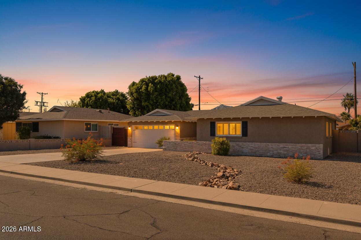A refined blend of mid-century character and modern design upgrades in the sought-after Hy-View neighborhood. Inside, a beautifully redesigned open floor plan centers on a kitchen with premium granite countertops, a sizable island, a generous walk-in chef's pantry, and an adjacent full-size laundry room. Kitchen and bath skylights, along with a newly installed 8-ft living-room picture window and matching 8-ft patio door in high-end bronze anodized aluminum frames, fill the home with natural light. A fourth bedroom ideal as a home office is a rare find in a size range where most homes are 3/2. Outside, a professionally redesigned backyard is built for entertaining: a resurfaced deep-end pool framed by privacy hedges, artificial turf, a covered patio, and stained-wood plank accent walls. The covered patio adds an attached utility storeroom or studio, while the side yard is reimagined as an open-air gym. A professionally coated garage floor, updated pool equipment, and a 2024 electrical panel round out the improvements. Minutes from Papago Park, the Desert Botanical Garden, and Old Town Scottsdale, with walking, hiking, and cycling routes right outside the front door and a glimpse of Camelback's summit from the living room. Bordering the prestigious enclaves of Arcadia and Paradise Valley, among the Valley's most sought-after addresses for renowned dining and high-end resort and entertainment. Move-in ready and waiting for its most discerning buyer!