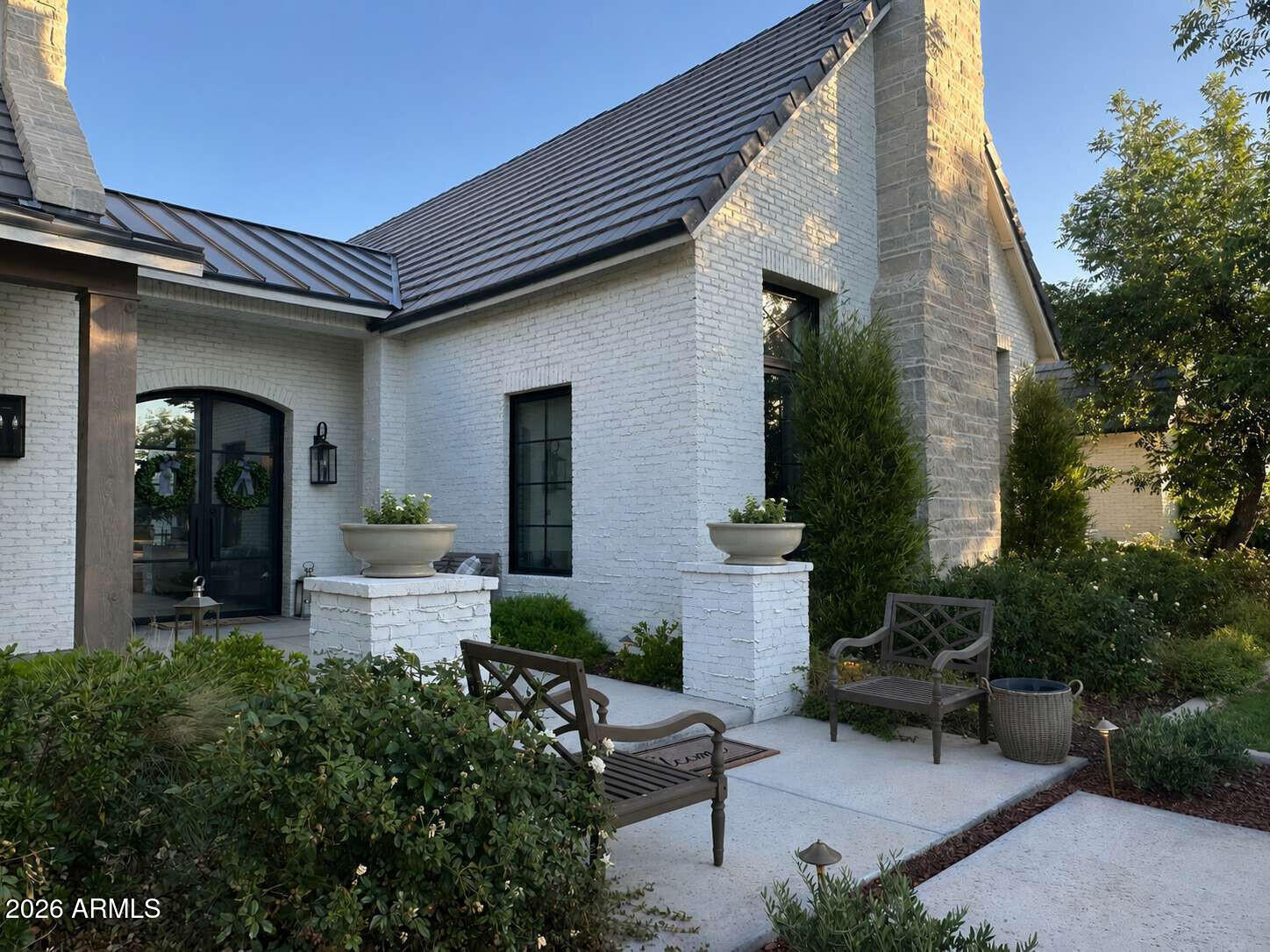 If the charm of the English countryside captures your heart - welcome home! You are sure to fall in love with this extraordinary estate home nestled within the most picturesque neighborhood. Welcome to Pecans Lights nestled inside The Pecans - a prestigious gated community in Queen Creek.
This residence was inspired by the timeless stone and brick architecture of the English countryside--and reimagined with a sophisticated modern twist--it offers refined luxury, thoughtful design, charm, and character at every turn. Completed in 2022 and set on nearly one acre of lush, tree-lined, garden-like grounds, this exceptional single-level estate spans 5,950 square feet and showcases the finest finishes and modern amenities for the most discerning buyer. From the moment you step inside, you are welcomed by exquisite millwork, architectural charm, and elegant design details, all beautifully finished in a soft, neutral palette that creates a warm yet sophisticated atmosphere.

Designed with flexibility for today's modern lifestyle, the home features six spacious bedrooms, each with its own ensuite bathroom, along with an additional powder bath for guests.

At the heart of the home lies a spectacular chef's kitchen thoughtfully designed for both everyday living and grand entertaining. Elegant white oak cabinetry, custom inset millwork, and marble countertops are paired with premier appliances from Wolf and True Refrigeration. Just beyond the main kitchen is a fully equipped prep kitchen (back kitchen) featuring a Scotsman built-in cabinet ice maker, quartz countertops, custom cabinetry, and an oversized farmhouse sink. This space is neatly concealed by custom white oak pocket doors, allowing for seamless entertaining. Both kitchens provide convenient access to the backyard's outdoor kitchen and expansive outdoor entertaining areas.

The primary suite is a luxurious private retreat featuring a spa-inspired bathroom with a custom natural stone and tile shower, soaking tub, marble countertops, and designer plumbing fixtures. A spacious dressing room and custom closet with a center island provide exceptional storage and organization. The suite also includes the rare convenience of its own private laundry room, complete with a sink and refrigeration amenities. An adjoining flex space offers additional versatility and could serve as a private office, nursery, wellness room, or additional storage.

Designed to be both beautiful and functional, the home offers exceptional comfort for modern living. The thoughtfully designed floor plan includes a friend's entry, a pocket office that functions perfectly as a household command center, and both formal and casual dining spaces. The casual dining room features custom built-in banquette seating. Additional highlights include a mudroom with custom cabinetry, Elkay bottle filler, a private motor court, and a spacious game or flex room featuring a cathedral beamed ceiling, natural stone fireplace, and clerestory windows that fill the space with natural light. A separate teen or guest flex space with kitchenette offers additional privacy and flexibility.

Outdoor living is equally impressive. The home features a large, screened porch with a double-sided fireplace, creating a comfortable and inviting space to enjoy the outdoors year-round. The fireplace connects seamlessly to the outdoor patio spaces. The beautifully designed outdoor spaces provide the feel of an English garden offering privacy and versatility, featuring an outdoor kitchen, pergola covered dining area, and multiple gathering spaces set within a picturesque landscape ideal for entertaining or relaxing.

This is more than a home--it is a rare opportunity to experience timeless architecture, exceptional character, charm, craftsmanship, and modern luxury in one of Queen Creek's most coveted communities. Every detail has been thoughtfully curated to create a home that is both elegant, warm, and welcoming, offering an unparalleled lifestyle of comfort, beauty, and refined living.