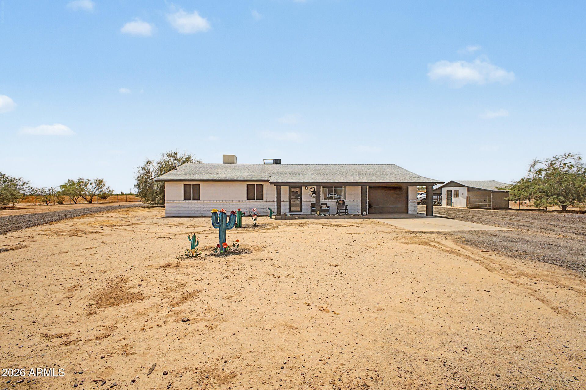 Remarkable horse property sits on a HUGE 4.79-acre lot! The charming single-level home offers 3 beds, 2 baths, & a 1-car garage. Enter to find inviting living spaces paired with abundant natural light and tile & laminate flooring throughout. The eat-in kitchen boasts built-in appliances and cabinetry for ample storage. Main bedroom has a private bathroom for added comfort. EXPANSIVE BACKYARD! With an RV gate & hookup, stall, tack room, storage shed, and arena, this gem is a dream for horse enthusiasts and outdoor hobbyists alike. Bring your toys, trucks, RVs, & horses - the property has plenty of space. PLUS! Leased solar panels help provide added energy efficiency and savings. Enjoy the peace of country living, complemented by fantastic views of the White Tank Mountains! What a RARE find!