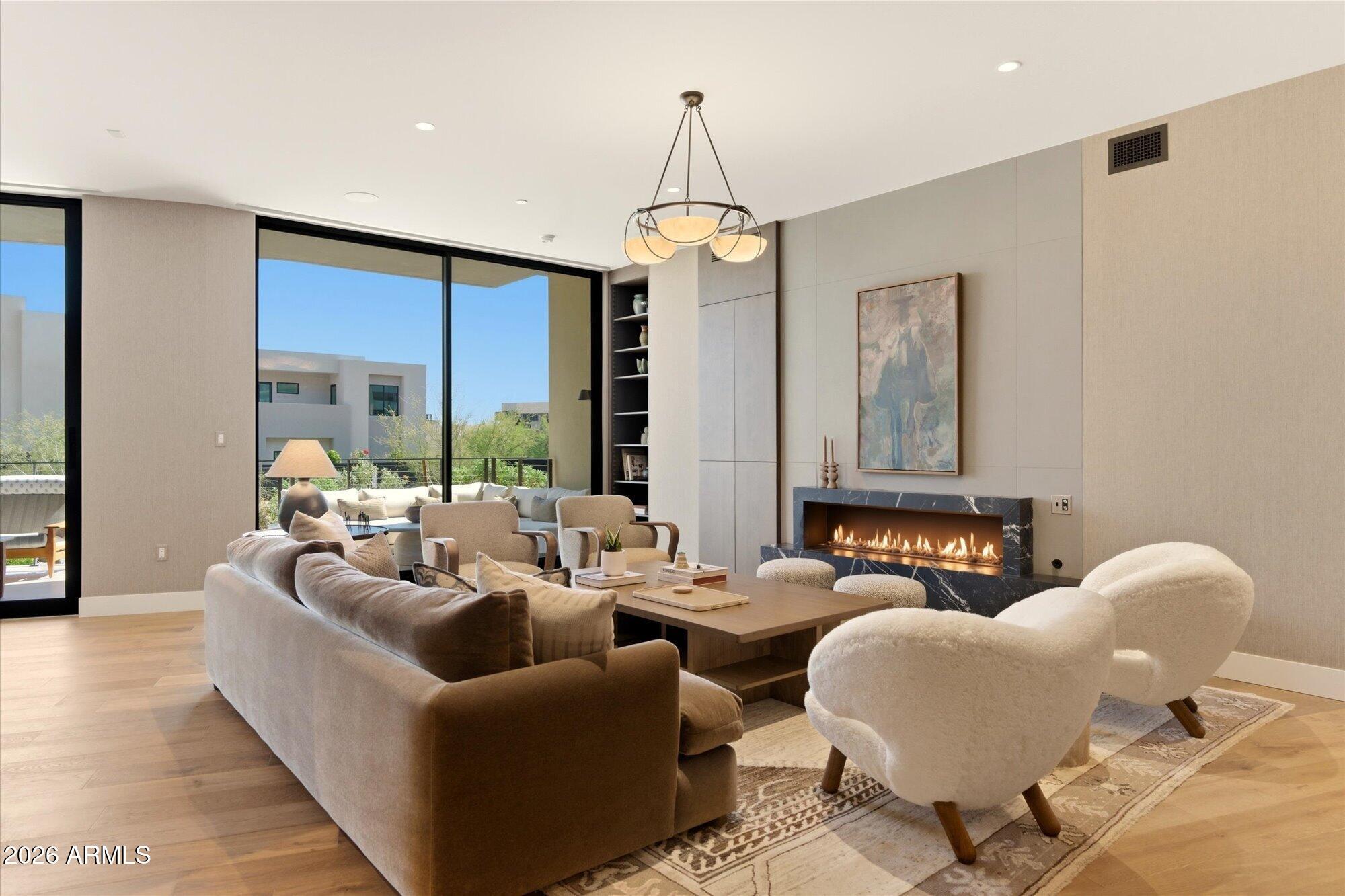 Tucked into the protected hillside at the base of Camelback Mountain, this refined residence offers a rare blend of privacy, ease, and resort-style living within the prestigious Ascent at The Phoenician.
Designed for effortless indoor-outdoor living, expansive retractable glass doors open to a generous private terrace, creating a seamless connection between sophisticated interiors and the surrounding desert landscape. The home offers direct access, single-level convenience, and an effortless lock-and-leave lifestyle. 
Thoughtfully curated interiors feature elevated finishes, open-concept living spaces, and a calm, modern aesthetic designed to complement the natural beauty of the setting. Furnishings by Vallone Design are available on a separate bill of sale for a turn-key experience.  The spacious outdoor living areas invite year-round entertaining, quiet mornings, and relaxed evenings beneath Camelback Mountain.  Residents enjoy access to the private rooftop terrace where sweeping views of Camelback Mountain, the McDowell Mountains, city lights, and Arizona sunsets create an unforgettable extension of the resort lifestyle.
Located within the guard-gated Ascent community, residents enjoy exclusive access to The Mountain Club and world-class resort amenities at The Phoenician's golf, spa, and dining venues.     An exceptional opportunity for buyers seeking refined simplicity, privacy, and effortless luxury in one of Scottsdale's most coveted resort communities.