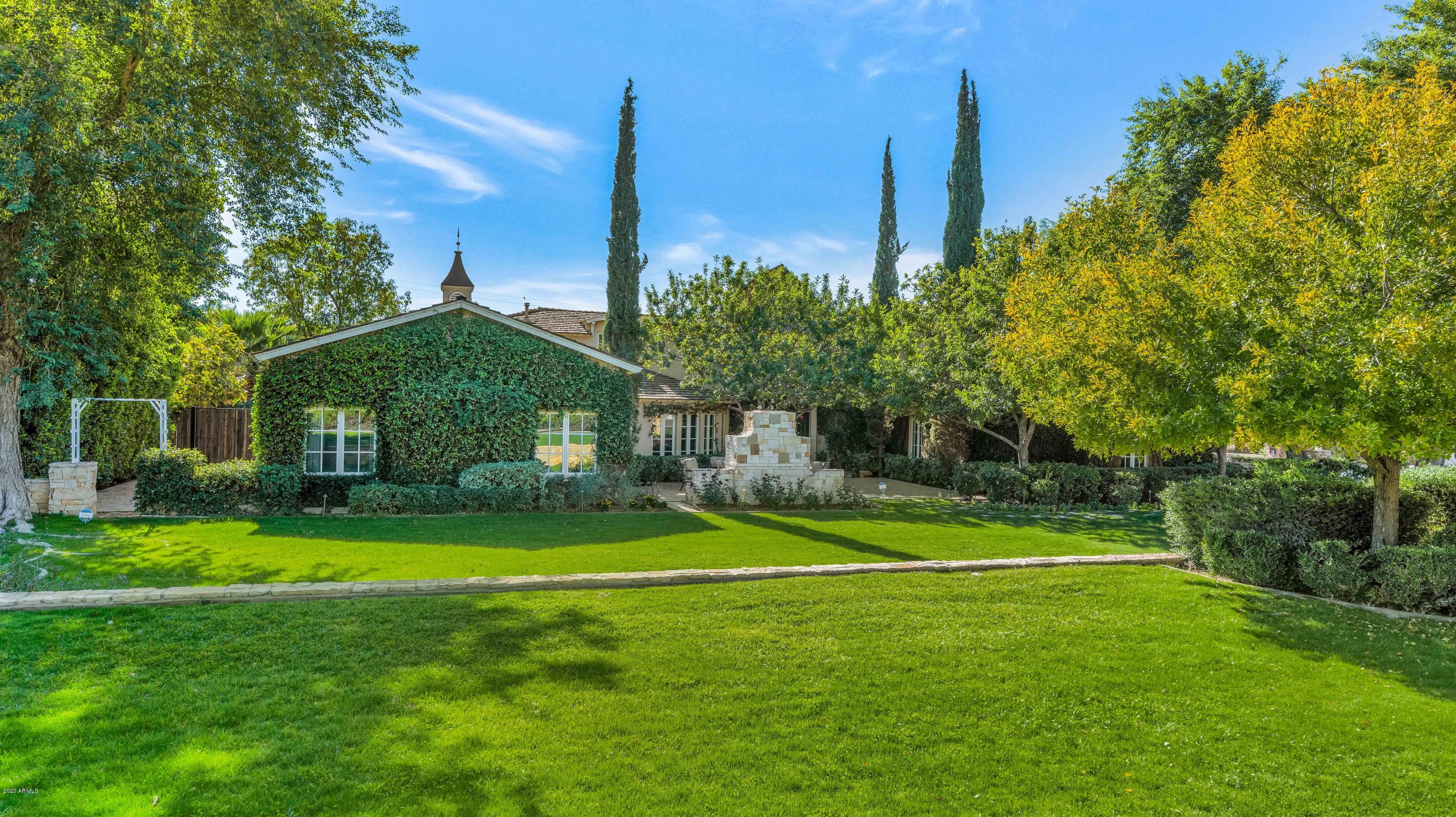 Featured in Dream Homes of The SouthWest, this is one of Arcadia's signature properties designed by Candelaria and remodeled by Nance Construction. The classic design has a european feel and quality that is as impressive today as it was when it was built. The meandering front yard with beautiful gardens and a sun filled courtyard leads to a gracious entrance and into a home that exudes elegance, yet is perfectly inviting. The formal spaces are designed for intimate gatherings or large scale entertaining, and the living spaces are designed for comfort. The island kitchen has a french country feel with top of the line fixtures and finishes, and a charming breakfast room, the great room has beautiful built-in cabinetry, and the master suite is pure romance with a balcony that frames breathtak Camelback Mountain views, and it has a lovely master bath. The home's many impressive features include a butler's pantry, wood flooring, custom tile, wainscoting, custom ceiling beams and multiple statement fireplaces. The grounds are stunning with a gorgeous pool, spa, outdoor kitchen, fenced garden and spectacular lush vegetation. An added bonus is the fast charging electric car station in garage. This is a very special home, with a very special address, waiting for another very special family to call it home!