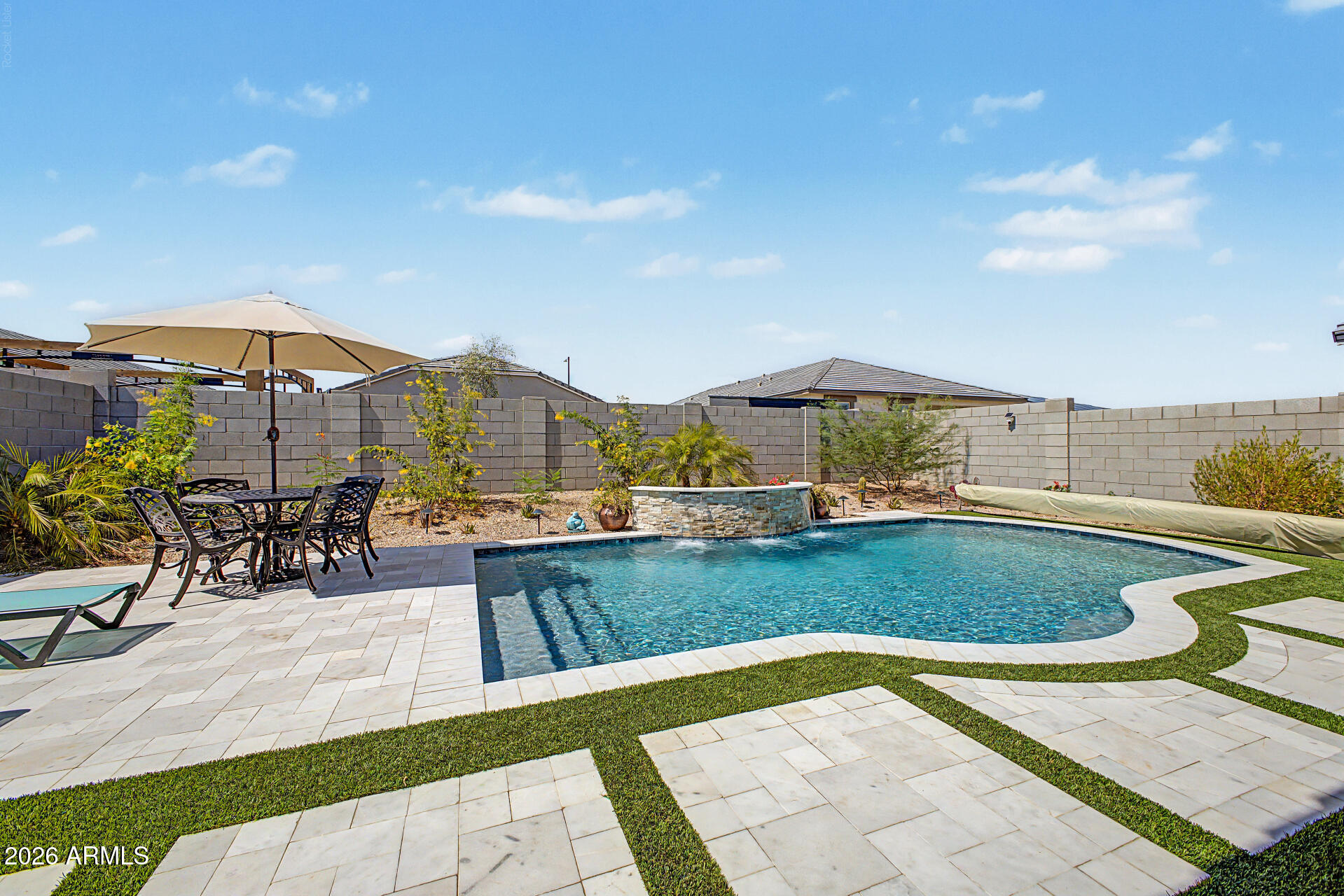 Better than new! This 2025 DR Horton Mockingbird offers 4 bedrooms, 2 baths, 1,788 sq ft, North/South exposure, and over $100,000 in premium upgrades. Enjoy a stunning PebbleTec play pool with stacked stone water feature, smart controls, color-changing lighting, travertine decking, and pre-wired for a pool heater. The professionally designed backyard features 644 sq ft of pet-friendly turf, RGB landscape lighting, citrus trees, palms, and a double gate. Inside, you'll find upgraded granite counters, designer backsplash, matte black hardware and fixtures, plantation shutters, floor-to-ceiling curtains, added recessed lighting, RO system, water softener, EV-ready garage, and washer/dryer included. Move-in ready and conveniently located near I-10, shopping, dining, and Costco.